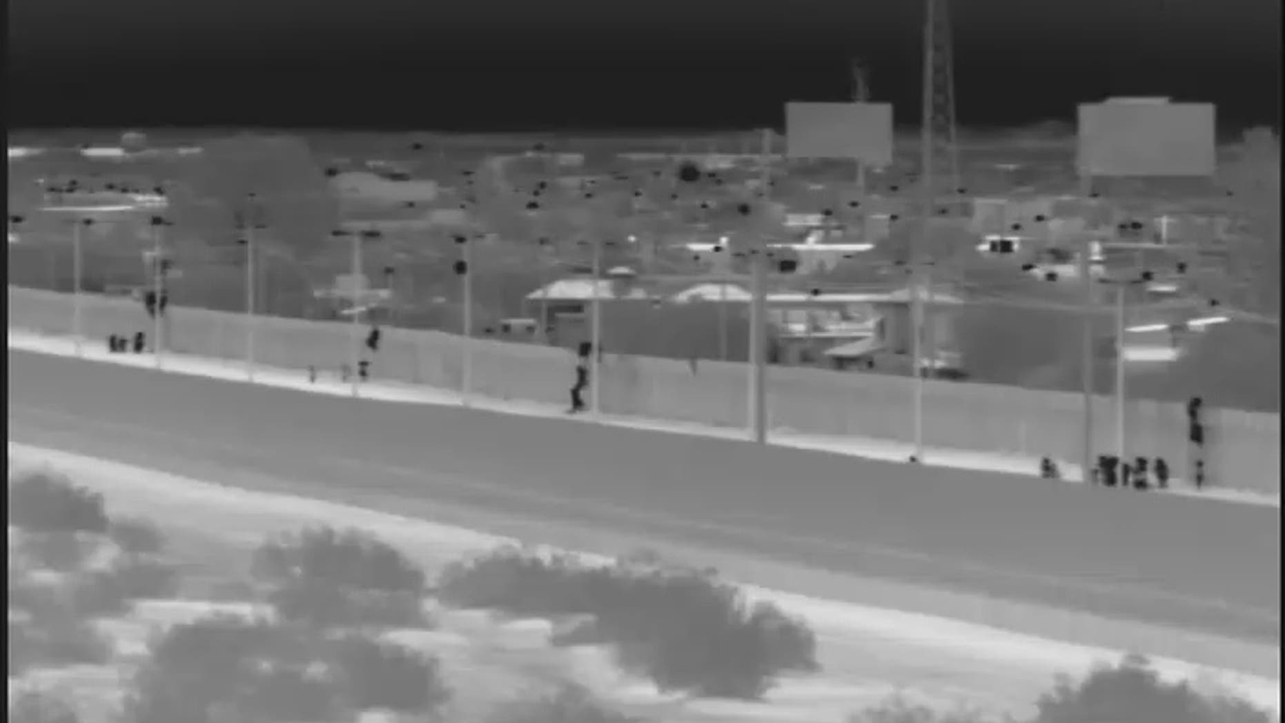 This image from video provided by the Yuma Sector Border Patrol shows a large group of Central American migrants being dropped over the U.S.-Mexico border wall east of the San Luis Port of Entry in Yuma, Arizona, on Friday, Oct. 19, 2018. (Yuma Sector Border Patrol via AP)