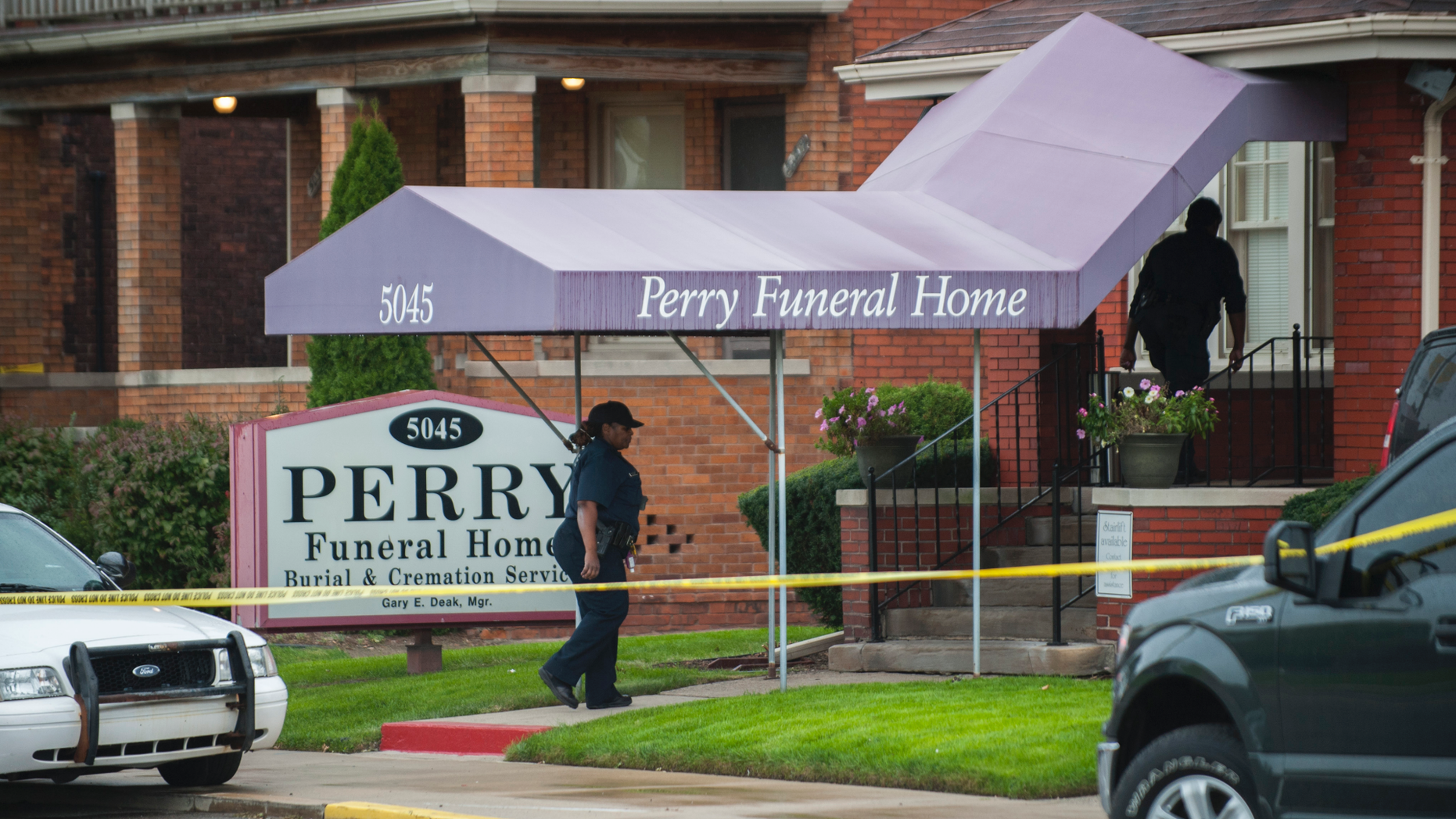 In this Friday, Oct. 19, 2018 photo, Detroit Police walk into the Perry Funeral Home in Detroit, where police removed the remains of 63 fetuses. (John T. Greilick/Detroit News via AP)