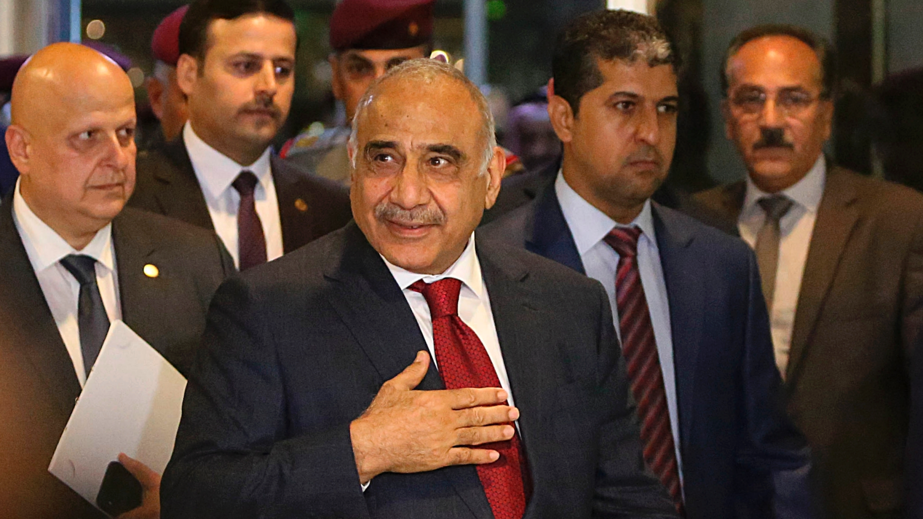 Prime Minister-designate Adel Abdul-Mahdi, center, arrives to the parliament building, in the heavily guarded Green Zone, in Baghdad, Iraq, Wednesday, Oct. 24, 2018. Iraq's parliament is convening to vote on Prime Minister-designate Adel Abdul-Mahdi's ministry appointments, and the parliament must confirm the appointments for the government to be sworn in. (AP Photo/Hadi Mizban)