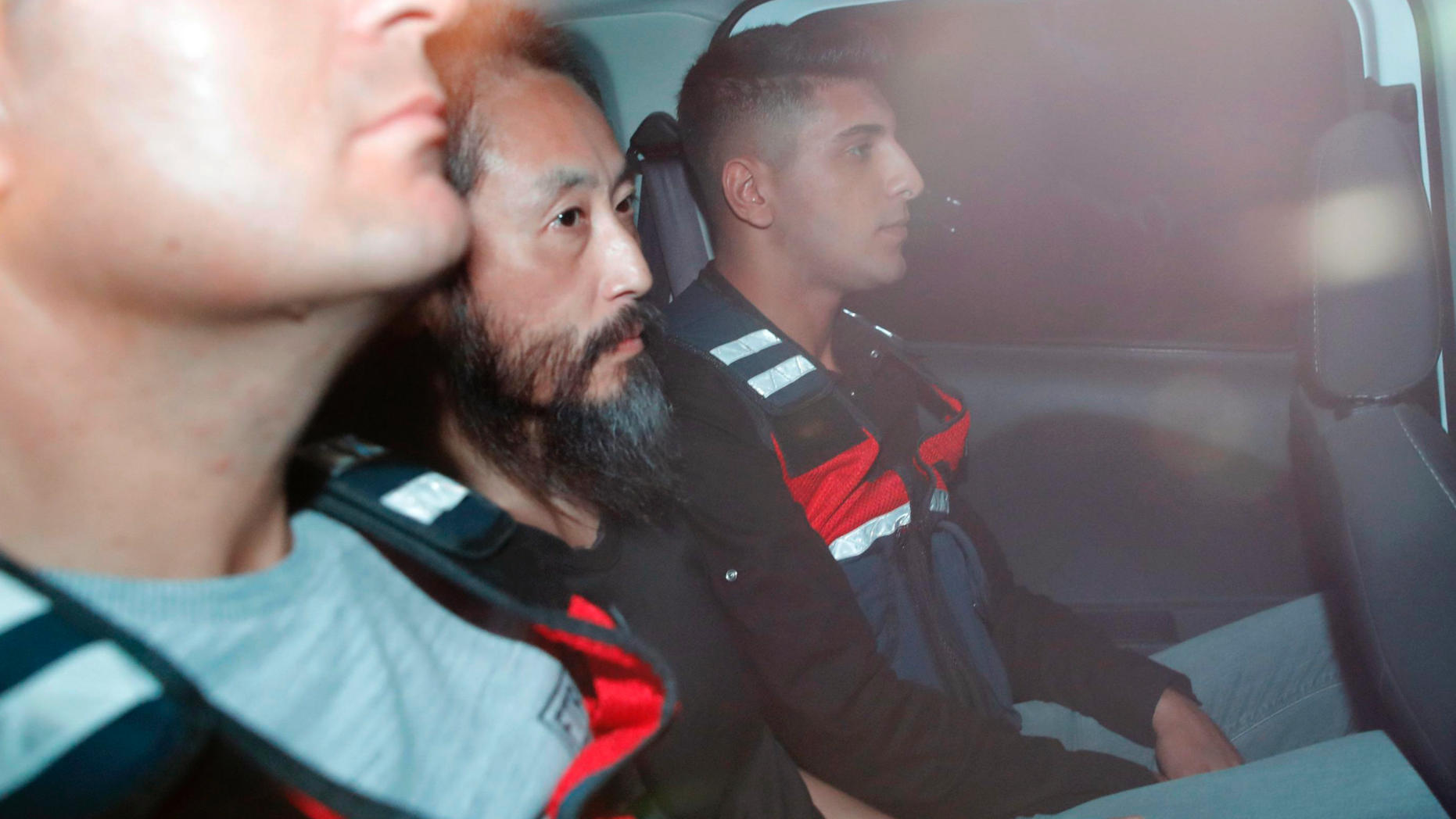 Japanese journalist Jumpei Yasuda, center, is driven out of the immigration center in Antakya, Turkey, Wednesday, Oct. 24, 2018. Yasuda was freed after more than three years of captivity in Syria Wednesday. (Yosuke Mizuno/Kyodo News via AP)
