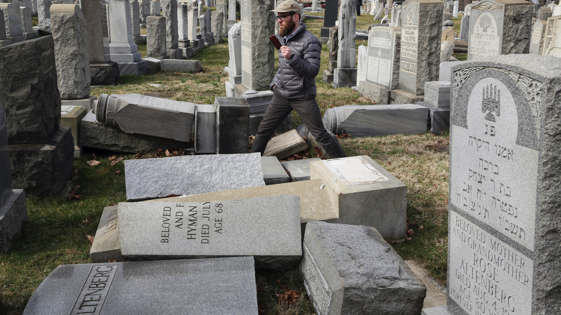 FILE - In this Feb. 27, 2017, file photo, Rabbi Joshua Bolton of the University of Pennsylvania's Hillel center surveys damaged headstones at Mount Carmel Cemetery in Philadelphia. The shooting rampage that killed more than 10 people at Pittsburgh's Tree of Life Synagogue on Saturday, Oct. 27, 2018, is being decried as the deadliest attack on Jews in U.S. history. Yet the carnage, however unprecedented, is not an aberration: Year after year, decade after decade, anti-Semitism proves to be among the most entrenched and pervasive forms of hatred and bigotry in the United States. (AP Photo/Jacqueline Larma, File)