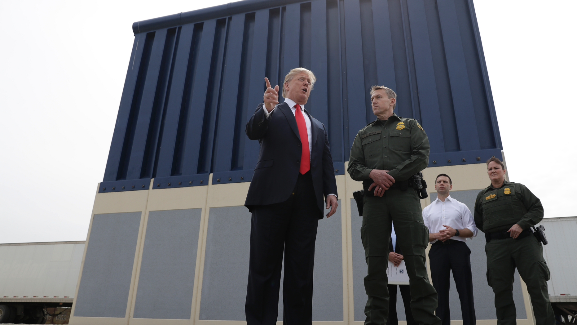 FILE - In this March 13, 2018, file photo, President Donald Trump speaks during as he reviews border wall prototypes, in San Diego, as Rodney Scott, the Border Patrol's San Diego sector chief, listens. Congress is heading toward a post-election showdown over President Donald Trump’s border wall, as GOP leaders signal they’re willing to engage in hardball tactics that could spark a partial government shutdown and the president revs up midterm crowds for the wall, a centerpiece of his 2016 campaign and a top White House priority. (AP Photo/Evan Vucci, File)