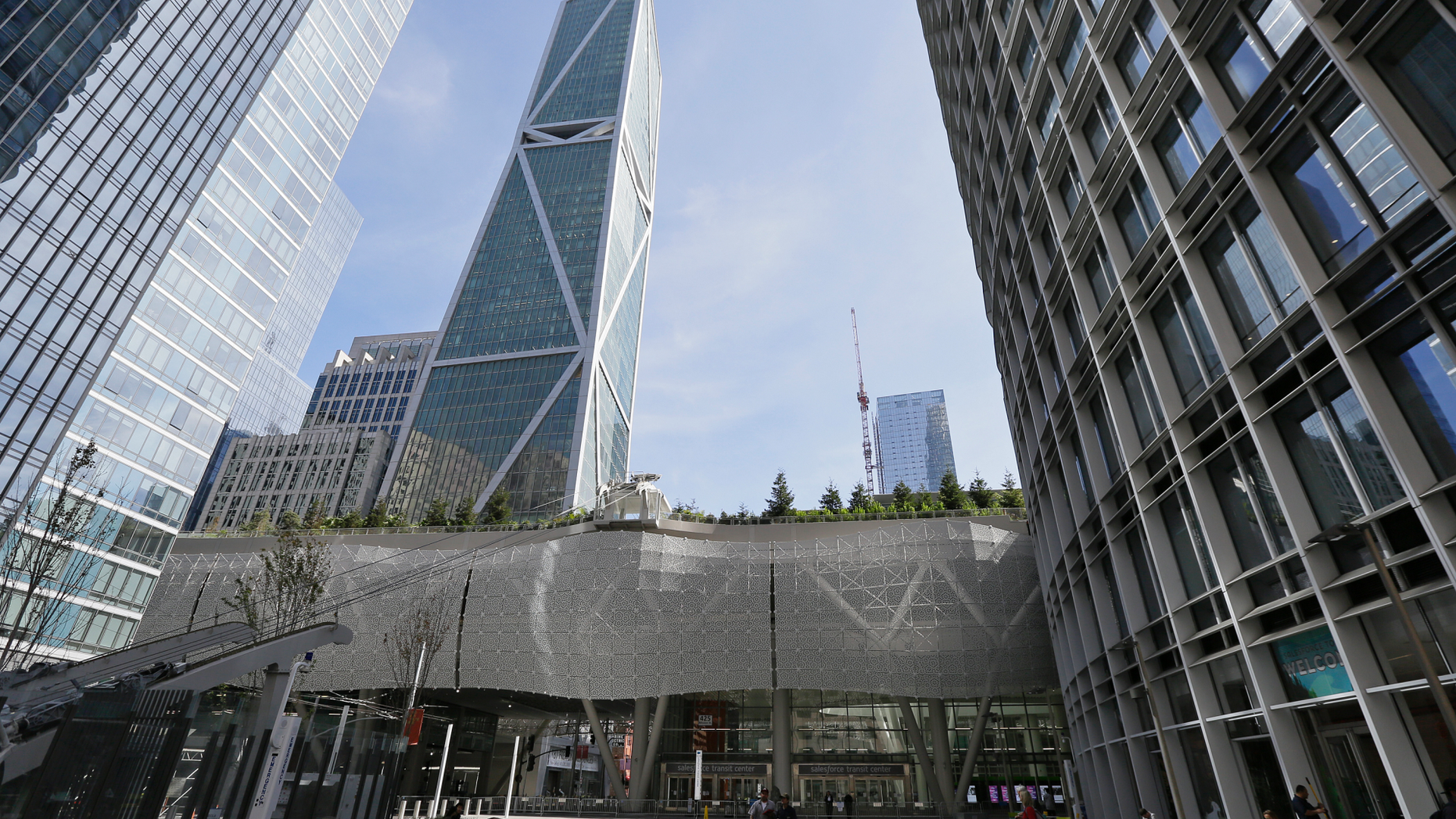FILE--In this Sept. 27, 2018, file photo, people walk through main plaza entryway to the closed Salesforce Transit Center in San Francisco. As two of the city's most vaunted buildings sink or crack, an earthquake study released Thursday, Oct. 4, recommended re-inspecting dozens of high-rises and beefing up construction codes for the growing crop of skyscrapers in the booming city. (AP Photo/Eric Risberg, file)