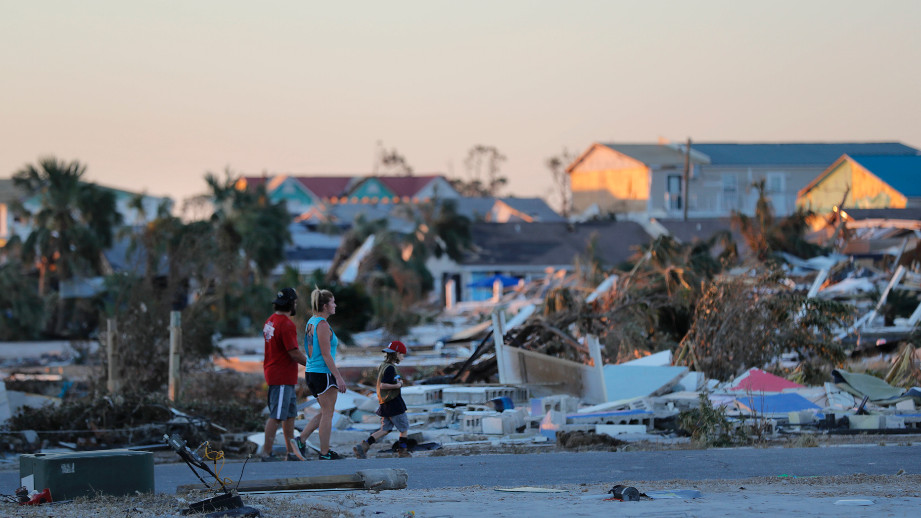 People walk amidst rubble in the aftermath of Hurricane Michael in Mexico Beach, Fla., Saturday, Oct. 13, 2018. (AP Photo/Gerald Herbert)