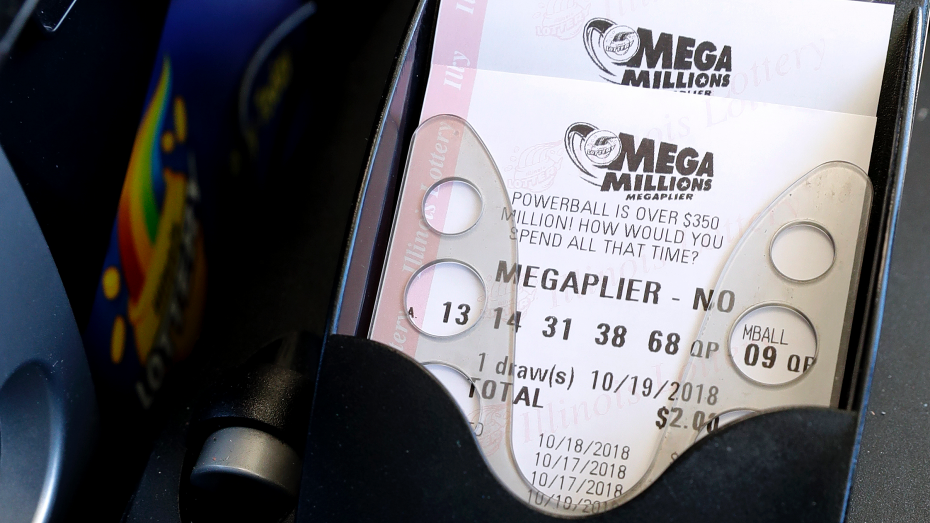 Mega Millions lottery tickets are printed out of a lottery machine at a convenience store Wednesday, Oct. 17, 2018, in Chicago. The estimated jackpot for Friday's drawing would be the second-largest lottery prize in U.S. history with a jackpot estimated to exceed $900 million. (AP Photo/Nam Y. Huh)