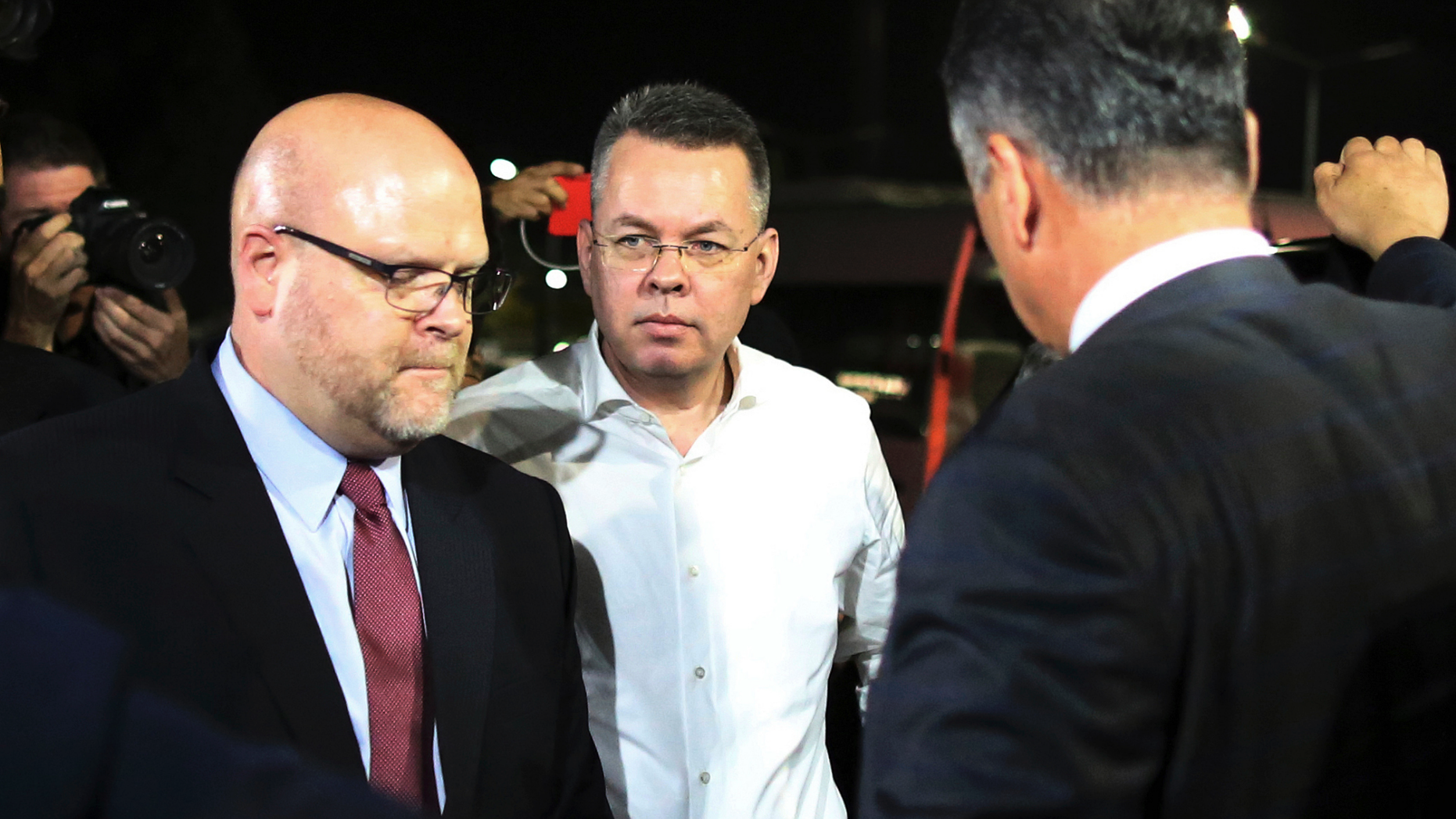 Pastor Andrew Brunson, center, and U.S. Charge d'Affaires Jeffrey Hovenier, left, arrive at Adnan Menderes airport for a flight to Germany after his release following his trial in Izmir, Turkey, Friday, Oct. 12, 2018, A Turkish court on Friday convicted an American pastor of terror charges but released him from house arrest and allowed him to leave Turkey, in a move that is likely to ease tensions between Turkey and the United. (AP Photo/Emre Tazegul)