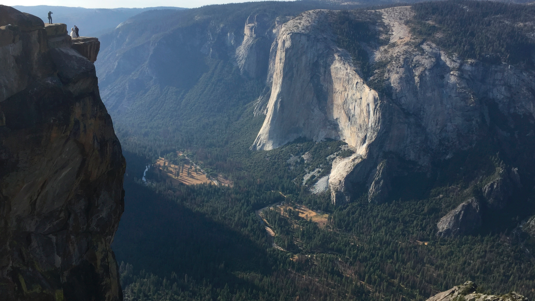 FILE - In this Sept. 27, 2018 file photo a wedding couple are seen being photographed at Taft Point in California's Yosemite National Park. A Yosemite National Park official says two visitors have died in a fall from the popular overlook. Park rangers are trying to recover the bodies of a man and a woman Thursday, Oct.25, 2018. He didn't say when the couple fell from Taft Point. Gediman says the deaths are being investigated and offered no other information. (AP Photo/Amanda Lee Myers, File)