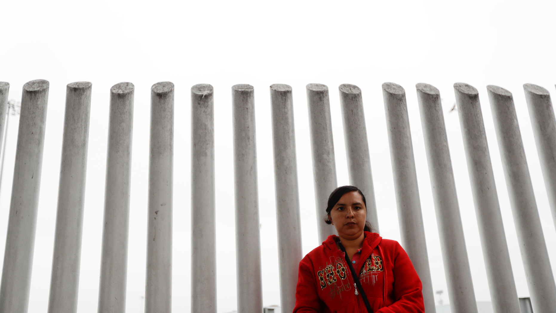 In this Oct. 23, 2018 image, Ana Delia Soto Duarte, who seeks asylum in the United States from her home in Guerrero, Mexico, waits in hopes of hearing her number called to cross the border in Tijuana, Mexico. The first obstacle that migrants in a giant caravan may face if they reach the U.S. border is a long wait in Mexico. To enter through San Diego, the wait in Mexico is a month or longer, spawning an unusual numbering system. (AP Photo/Gregory Bull)