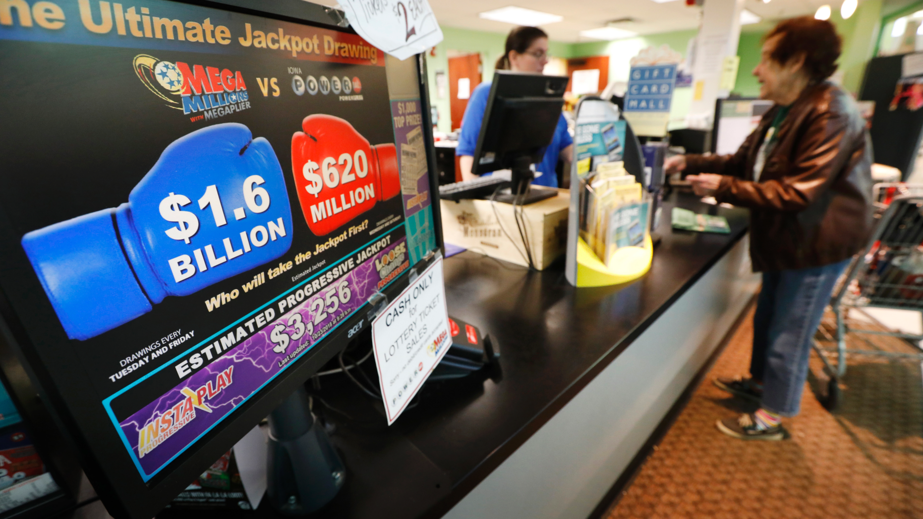 A customer buys a Mega Millions lottery ticket at a local grocery store, Tuesday, Oct. 23, 2018, in Des Moines, Iowa. Lottery players will have a chance at winning an estimated $1.6 billion jackpot in Tuesday night's Mega Millions drawing. (AP Photo/Charlie Neibergall)