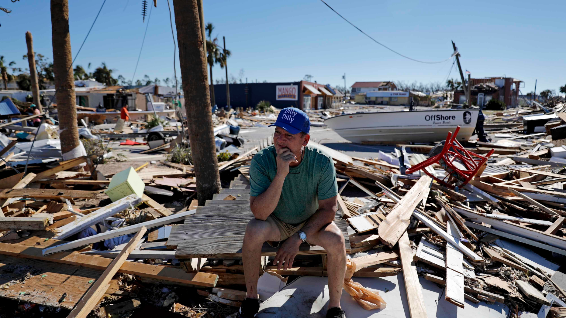 Hector Morales sits on a debris pile near his home which was destroyed by hurricane Michael in Mexico Beach, Fla., Friday, Oct. 12, 2018. "I have nothing else to do. I'm just waiting," said Morales as he wonders what he will do next. "I lost everything." (AP Photo/David Goldman)