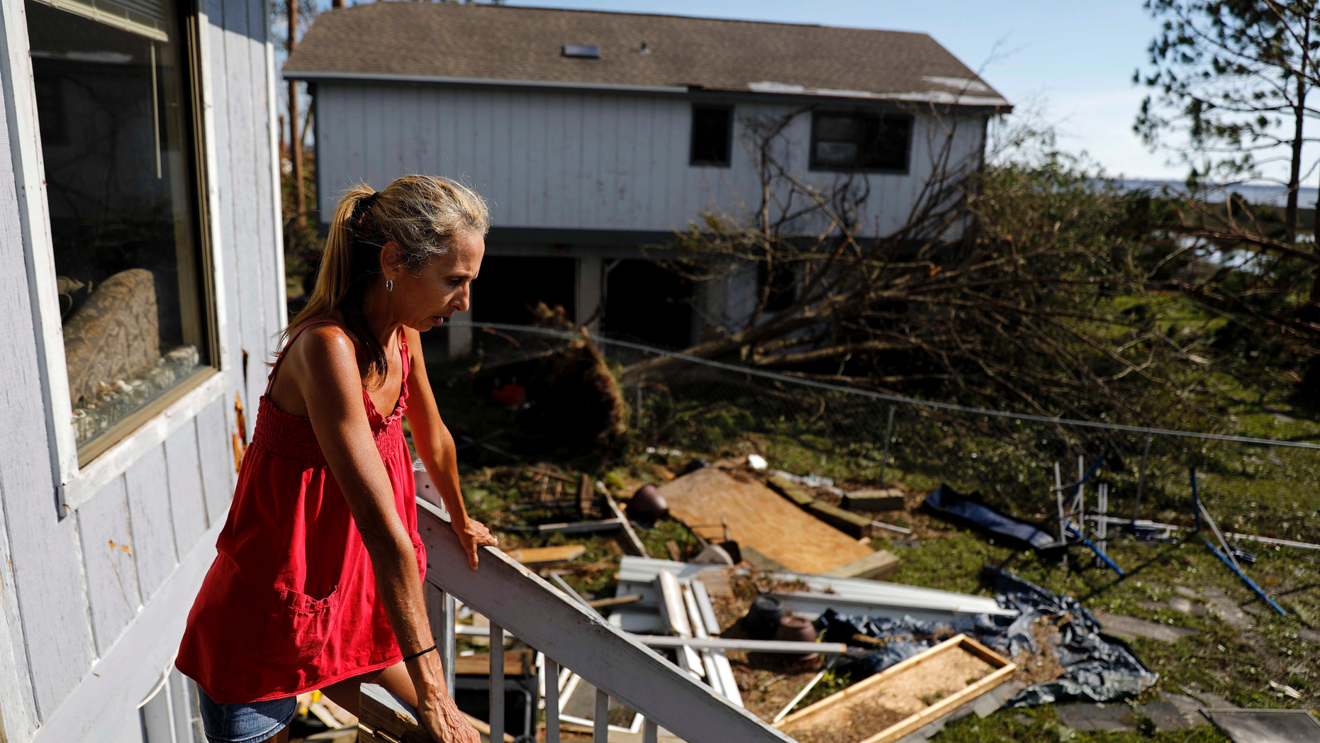 Monica Jones looks out over the debris littering her yard after riding out hurricane Michael in her home in Callaway, Fla., Thursday, Oct. 11, 2018. "I didn't think it was going to be this bad," said Jones on her decision to stay through the storm. The devastation inflicted by Hurricane Michael came into focus Thursday with rows upon rows of homes found smashed to pieces, and rescue crews began making their way into the stricken areas in hopes of accounting for hundreds of people who may have stayed behind. (AP Photo/David Goldman)