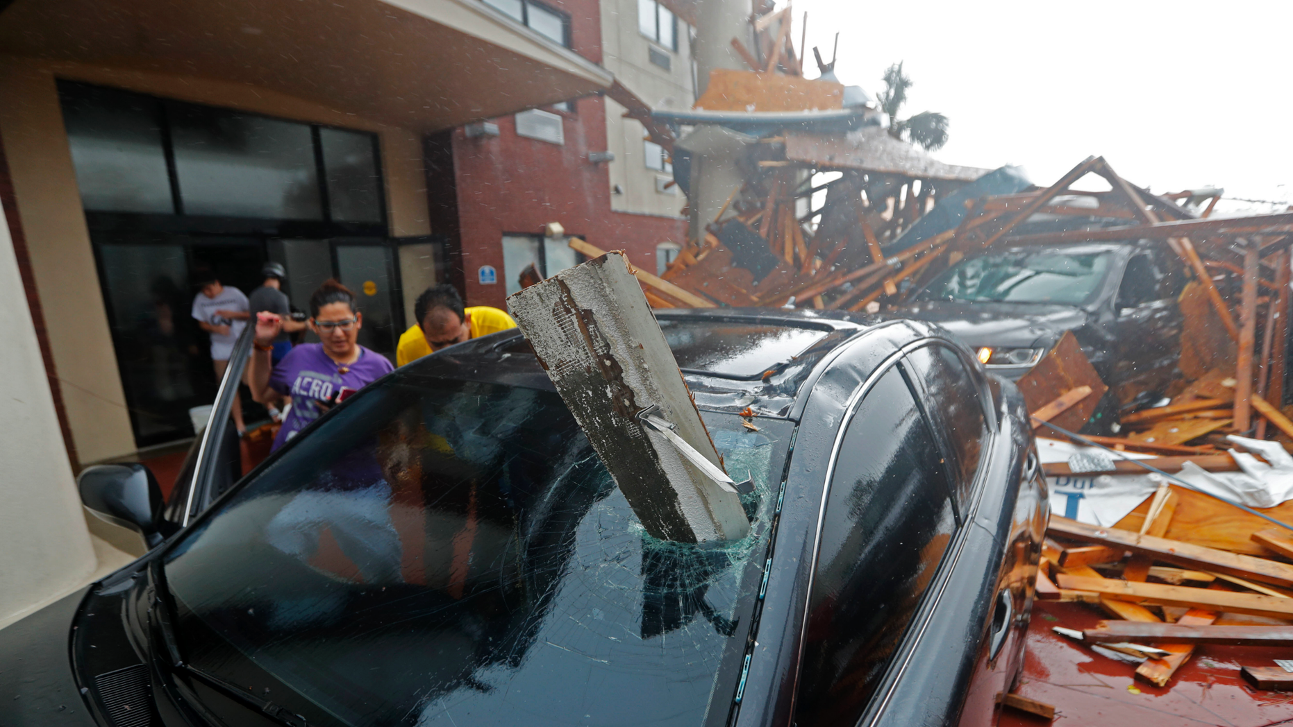 A woman checks on her vehicle as Hurricane Michael passes through after the hotel canopy had just collapsed in Panama City Beach Fla. Wednesday Oct. 10 2018