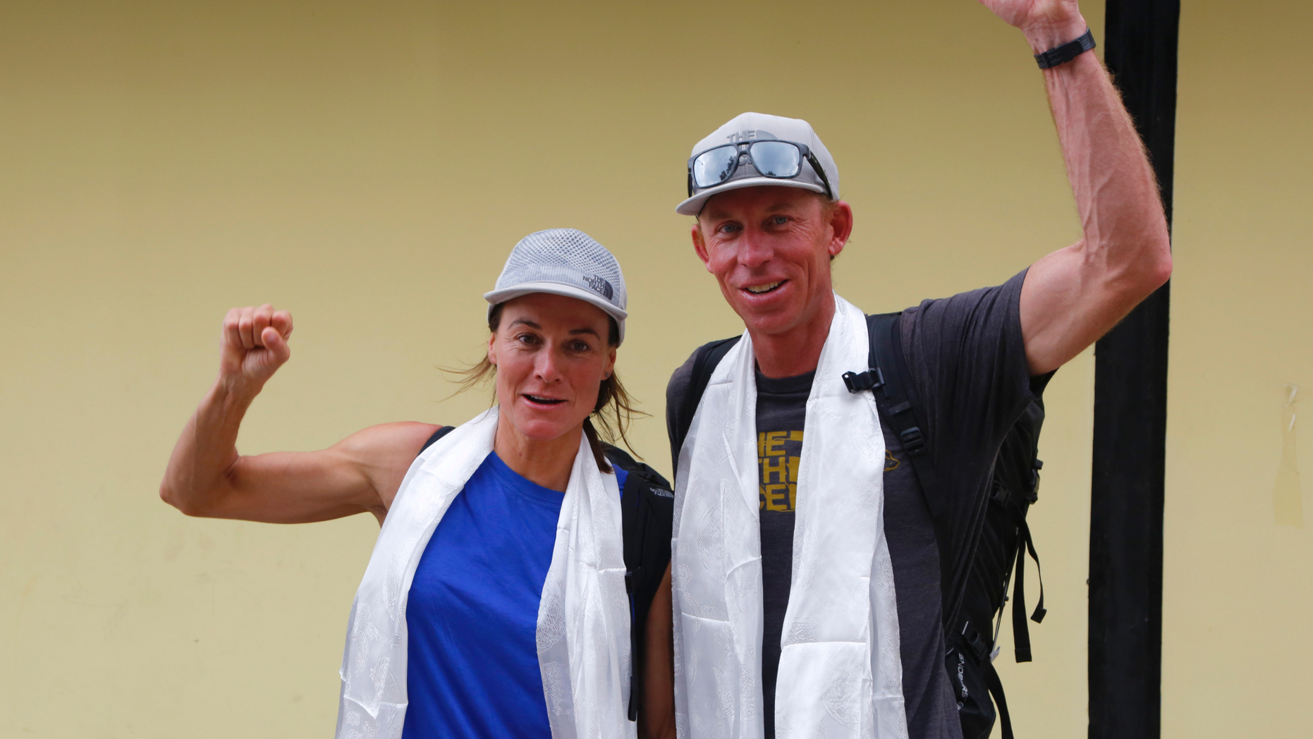 Hilaree Nelson of Telluride, Colorado, and James Morrison of Tahoe, California, raise their fists as the pair arrived in Kathmandu, Nepal, Thursday, Oct. 4, 2018. The two American extreme skiers who overcame weather conditions, delays, equipment and oxygen issues to successfully ski down from the summit of the world's fourth-highest peak Mount Lhotse returned safely from the mountains. (AP Photo/Niranjan Shrestha)