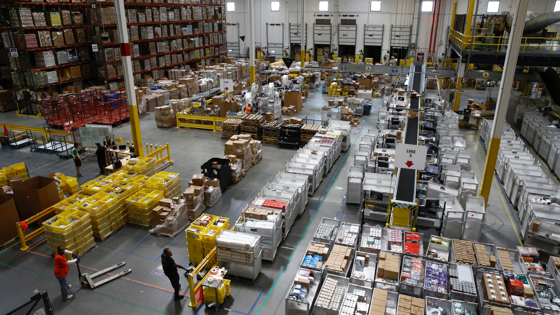 FILE- In this Aug. 3, 2017, file photo, workers prepare to move products at an Amazon fulfillment center in Baltimore. (AP Photo/Patrick Semansky, File)