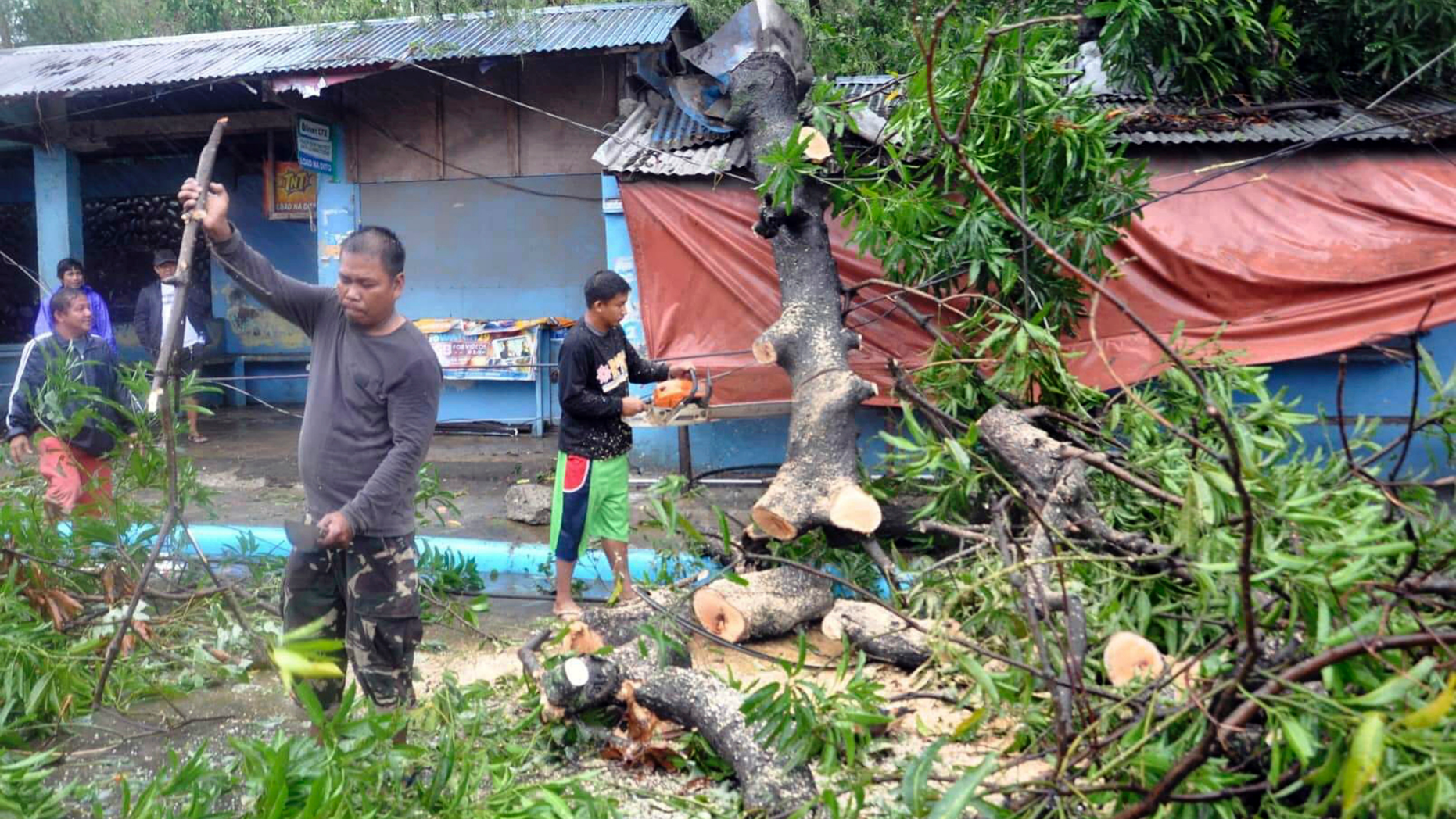 Workers clear the road off toppled trees after Typhoon Yutu slammed Isabela province in northeastern Philippines Tuesday, Oct. 30, 2018. A strong typhoon battered the northern Philippines on Tuesday, though officials were hopeful that successful evacuations would help avoid a repeat of the death and destruction wrought by a powerful storm last month. (AP Photo)
