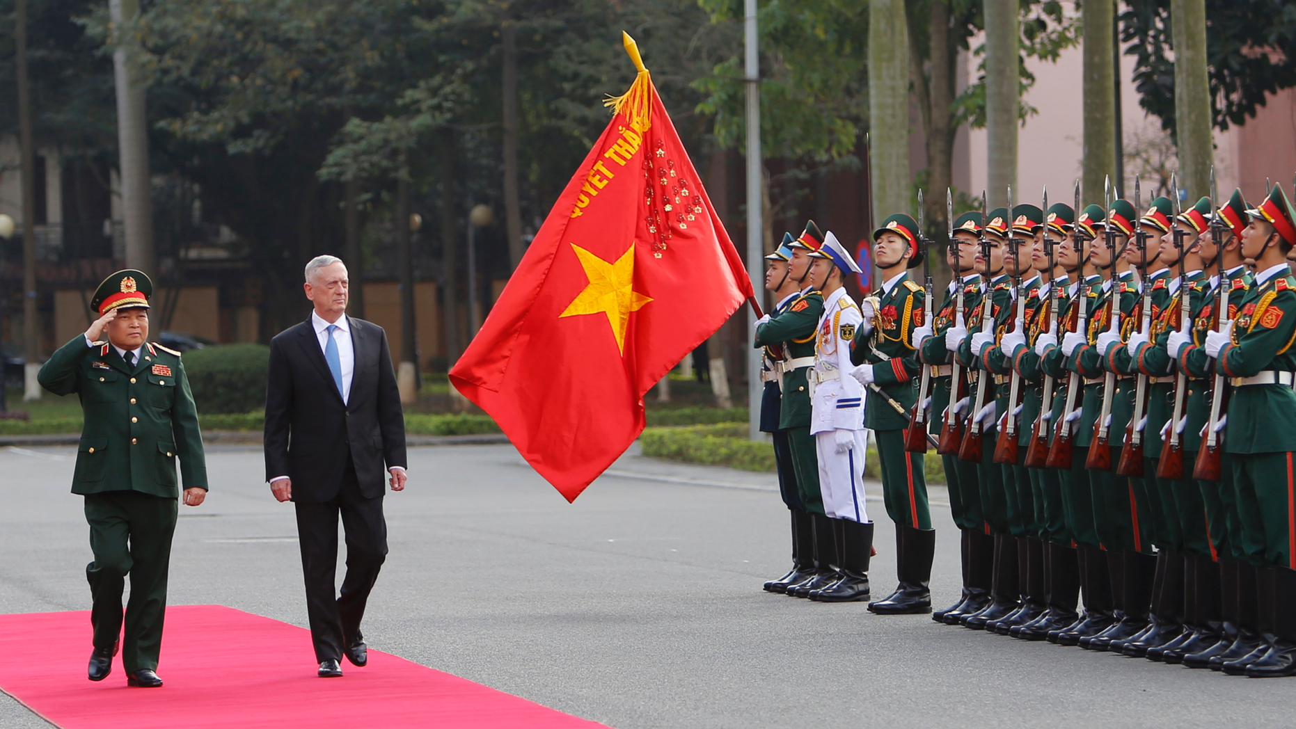 FILE - In this Jan. 25, 2018, file photo, U.S. Defense Secretary Jim Mattis and his Vietnamese counterpart Ngo Xuan Lich, left, review an honor guard in Hanoi, Vietnam. By making a rare second trip this year to Vietnam, Mattis is showing how intensively the Trump administration is trying to counter China’s military assertiveness by cozying up to smaller nations in the region who share American wariness about Chinese intentions. The visit beginning Tuesday also shows how far U.S.-Vietnamese relations have advanced since the tumultuous years of the Vietnam War, whose legacy includes a continued search for the remains of U.S. war dead on Vietnamese soil. (AP Photo/Tran Van Minh, File)