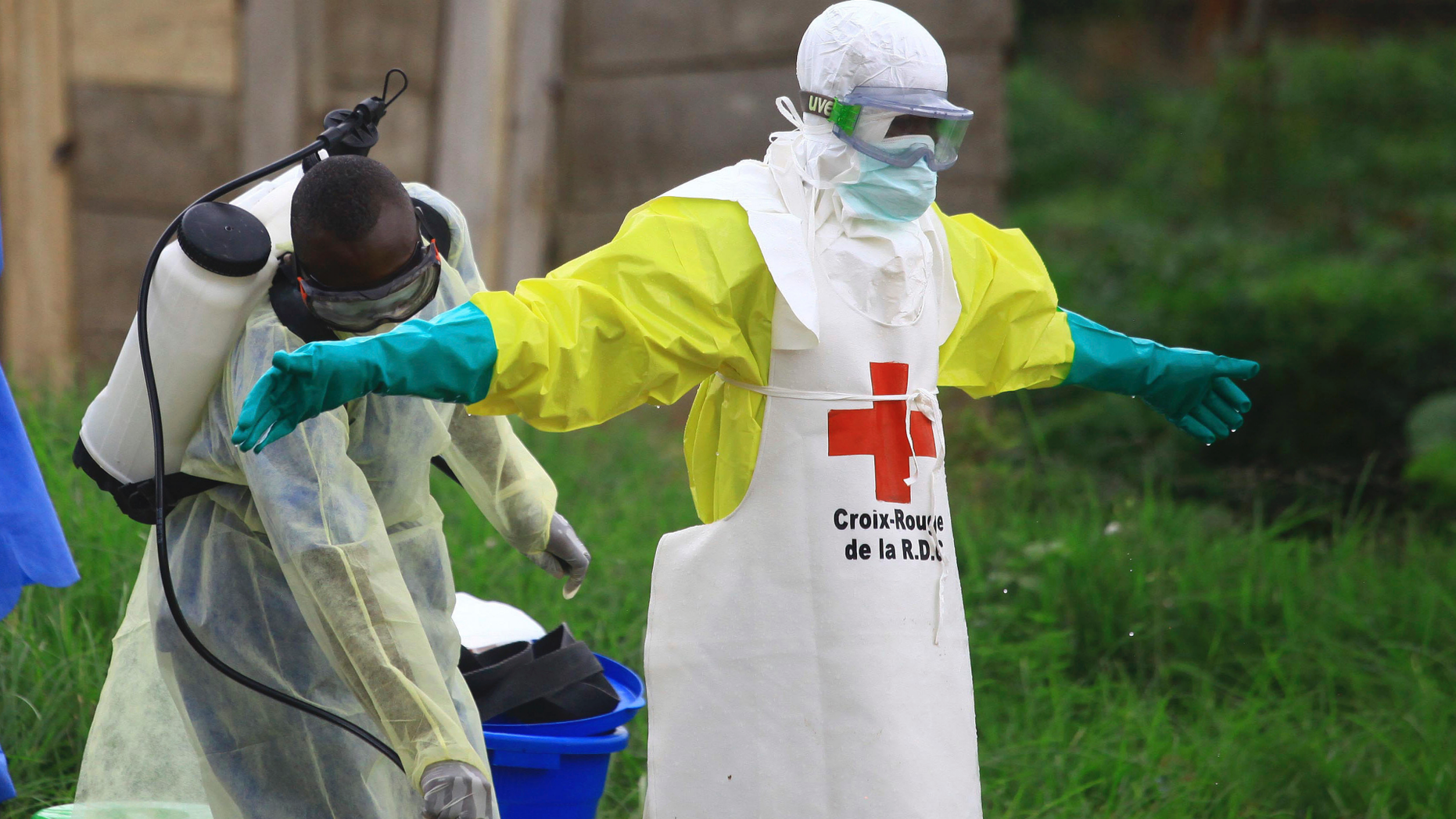 In this Sunday, Sept 9, 2018 file photo, a health worker sprays disinfectant on his colleague after working at an Ebola treatment centre in Beni, Eastern Congo. 