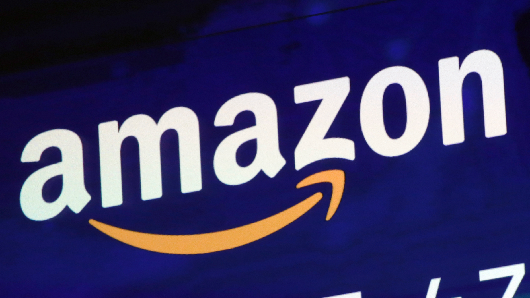 FILE - In this July 27, 2018 file photo, the logo for Amazon is displayed on a screen at the Nasdaq MarketSite in New York. Amazon is boosting its minimum wage for all U.S. workers to $15 per hour starting next month. The company said Tuesday, Oct. 2, that the wage hike will benefit more than 350,000 workers, which includes full-time, part-time, temporary and seasonal positions. (AP Photo/Richard Drew, File)