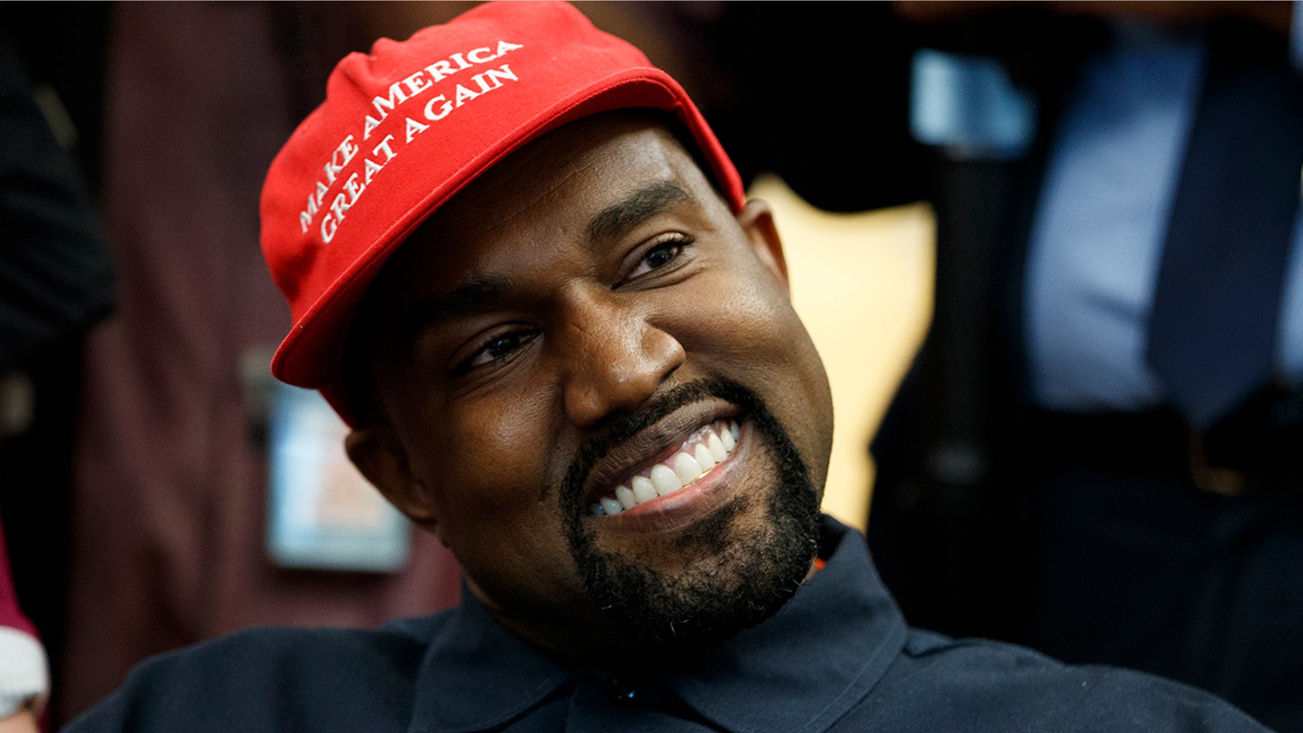 Rapper Kanye West smiles as he listens to a question from a reporter during a meeting in the Oval Office of the White House with President Donald Trump.