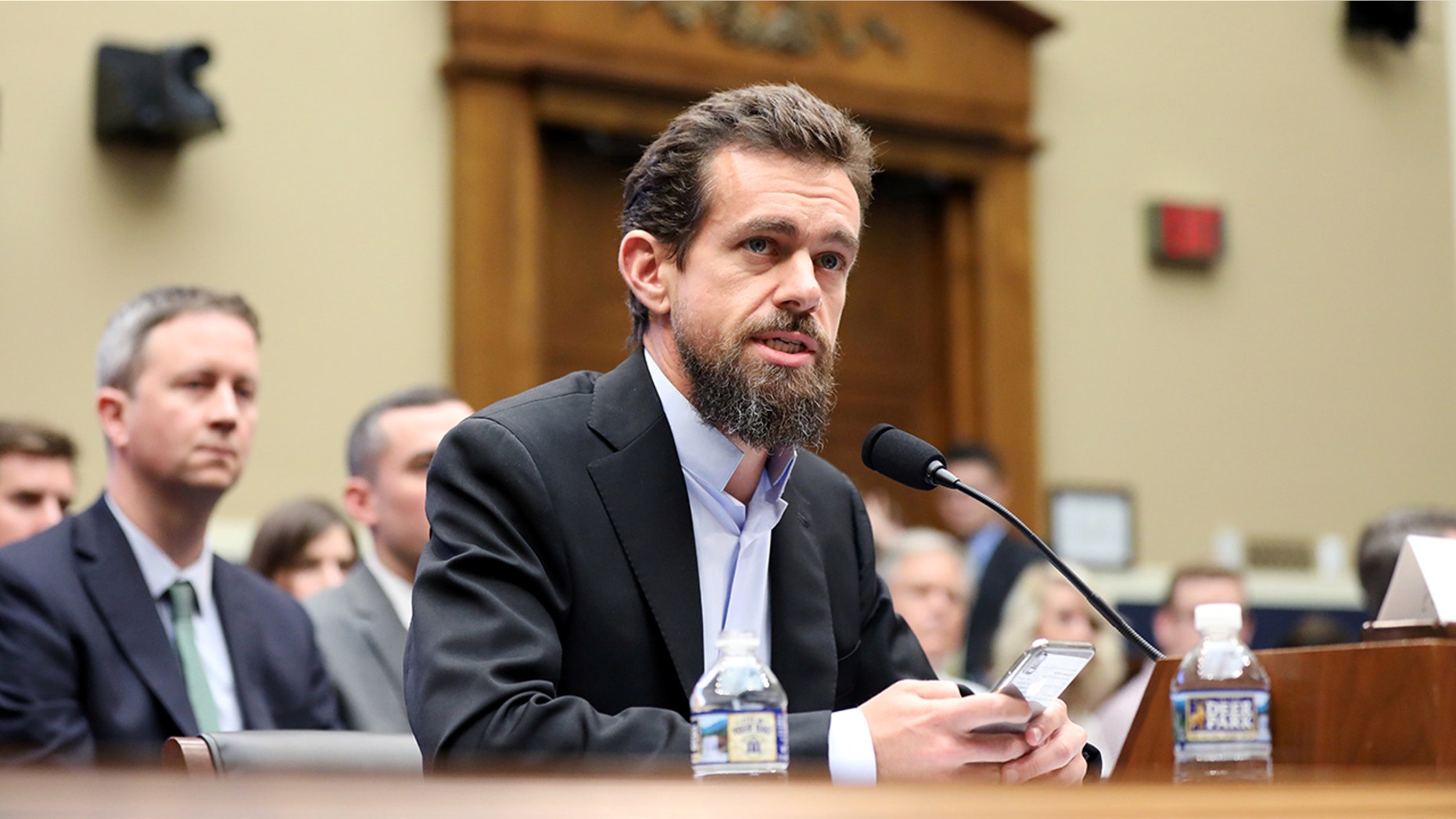 Twitter co-founder Jack Dorsey holding a phone during a Sept. 5 appearance on Capitol Hill.
