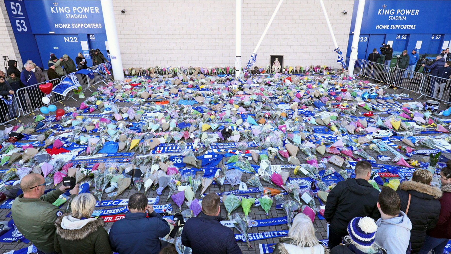 Supporters pay tribute outside Leicester City Football Club after a helicopter crashed in flames the day before, in Leicester, England, Sunday, Oct. 28, 2018. A helicopter belonging to Leicester City's owner, Thai billionaire Vichai Srivaddhanaprabha, crashed in flames in a car park next to the soccer club's stadium shortly after it took off from the field following a Premier League game on Saturday night. (Aaron Chown/PA via AP)