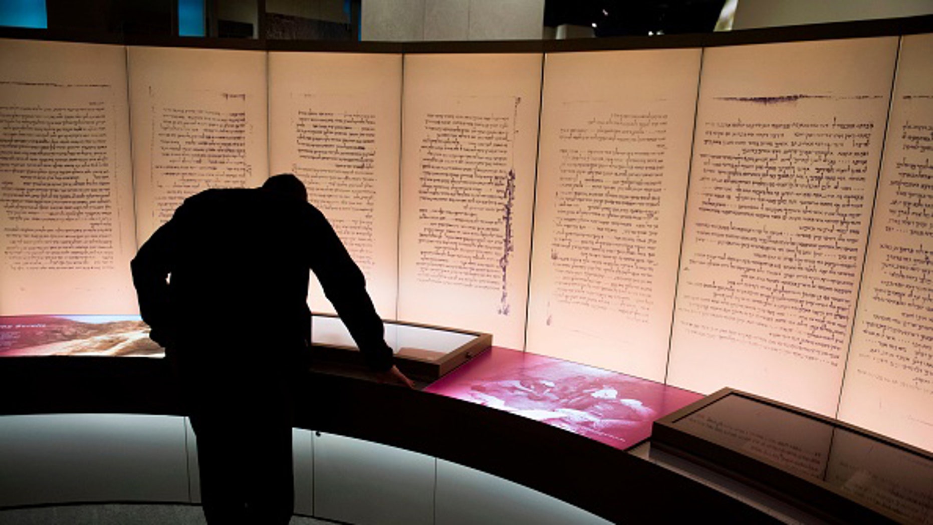 File photo - a visitor looks at an exhibit about the Dead Sea scrolls during a media preview of the Museum of the Bible in Washington, DC, Nov. 14, 2017.