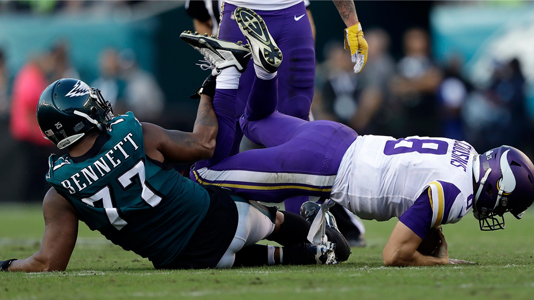 Philadelphia Eagles' Michael Bennett, left, hits Minnesota Vikings' Kirk Cousins during the first half of an NFL football game