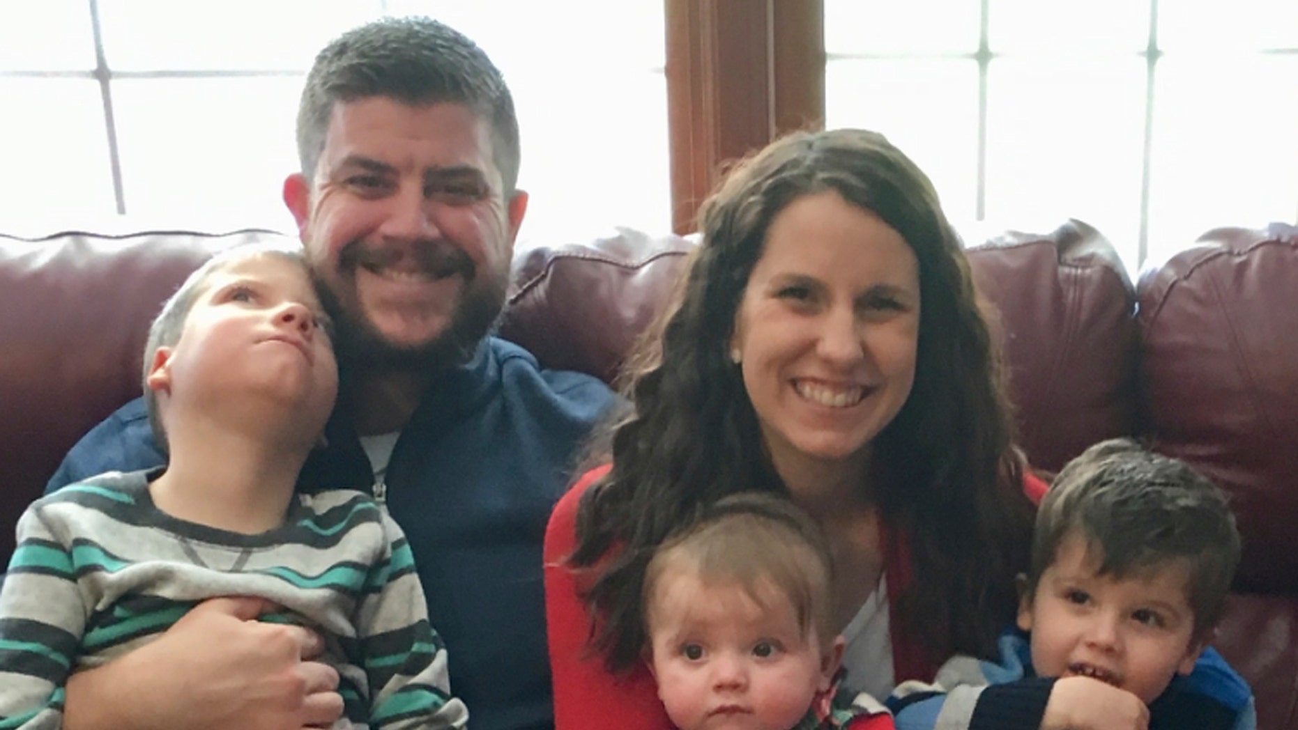 In this family-owned December 10, 2017 photo, Jon and Kari Kilquist are sitting with their children. From left to right, Will, born with a list of mysterious symptoms, Emmy and Owen at their home in Murphysboro, Illinois. 