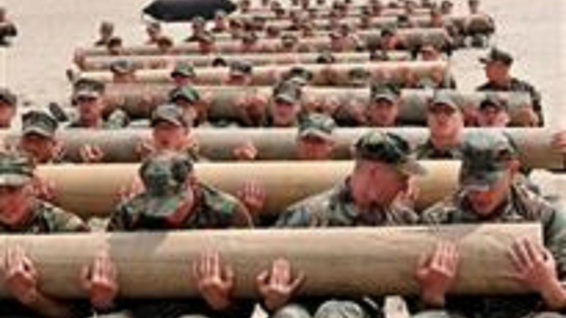 U.S. Navy SEAL candidates use teamwork to perform physical training exercises with 600-pound logs.