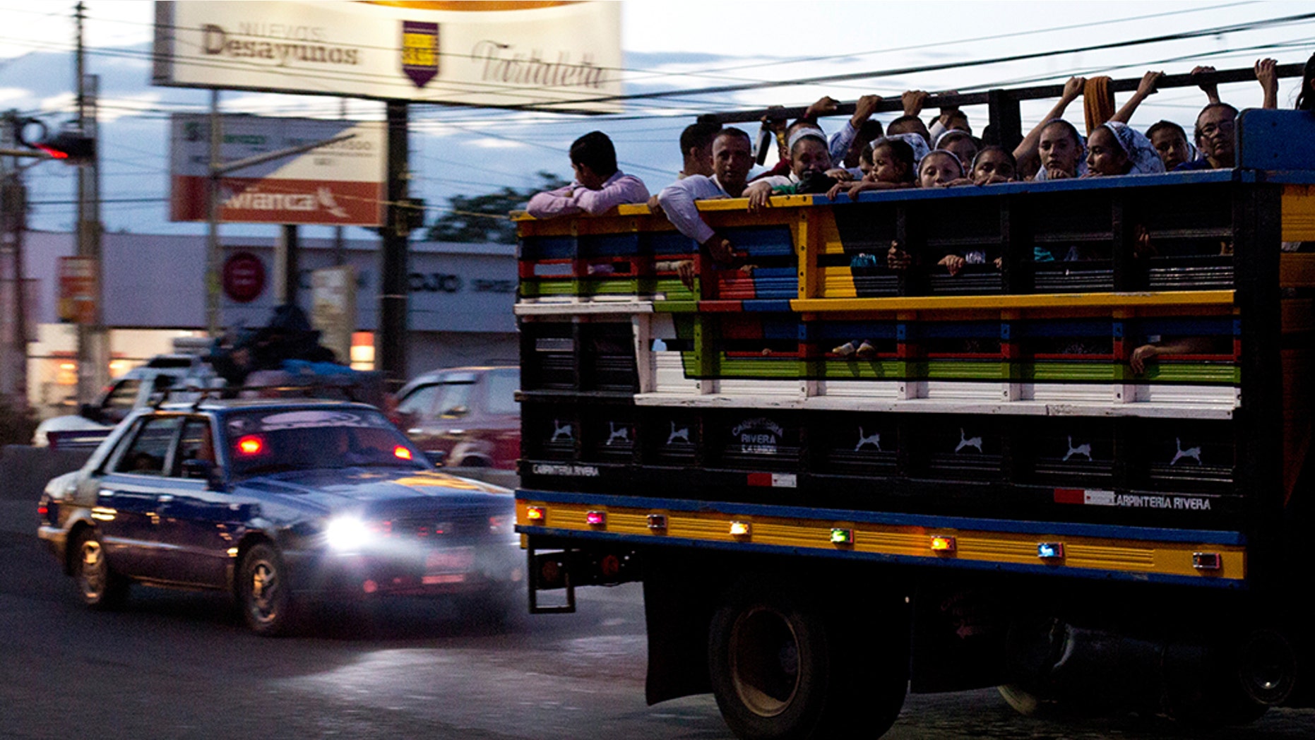 Commuters ride in the back of a pickup as night falls in San Miguel, El Salvador. It’s a small country both geographically and by population, home to 6.5 million inhabitants. The International Organization for Migration estimates that another 1.35 million Salvadorans live in the United States. (AP Photo/Rebecca Blackwell, File)