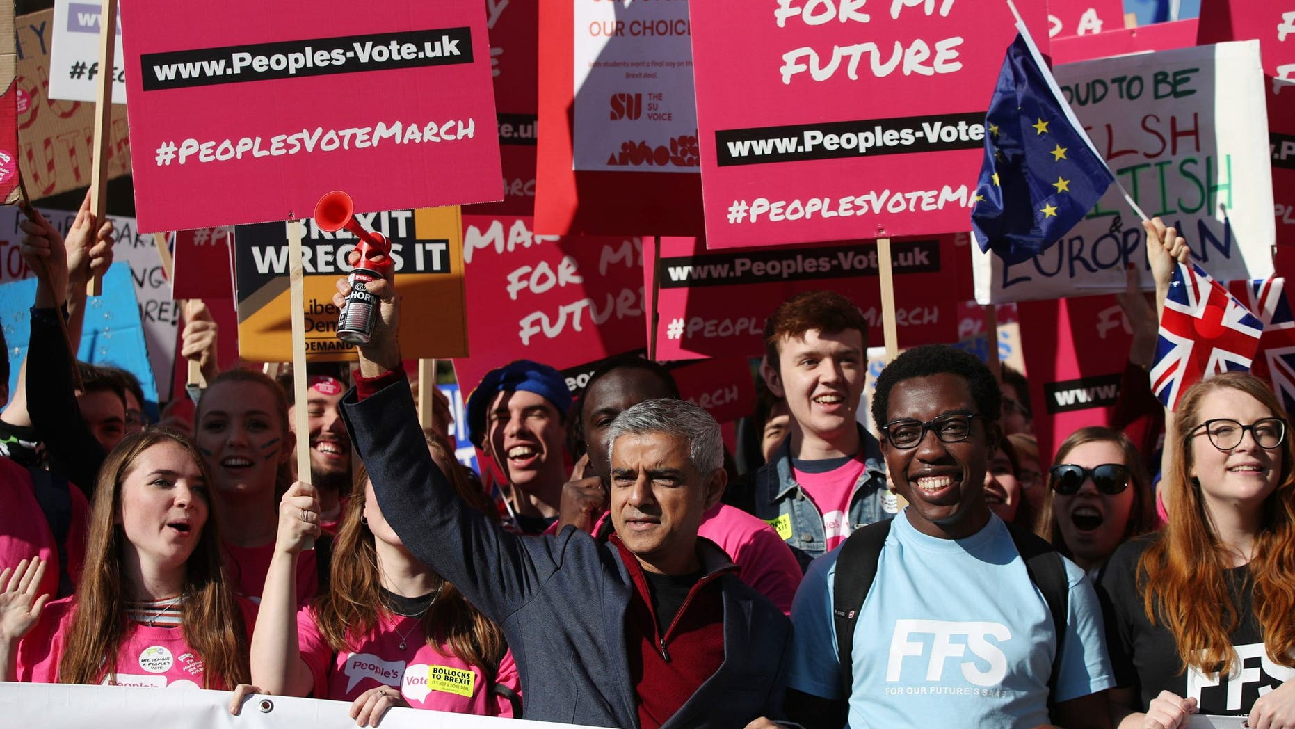 Mayor of London Sadiq Khan, front center, holds a klaxon horn, as he joins protesters in the People's Vote March for the Future, in London, Saturday Oct. 20, 2018. Some thousands of protesters are marching through central London, Saturday, to demand a new referendum on Britain’s Brexit departure from the European Union.