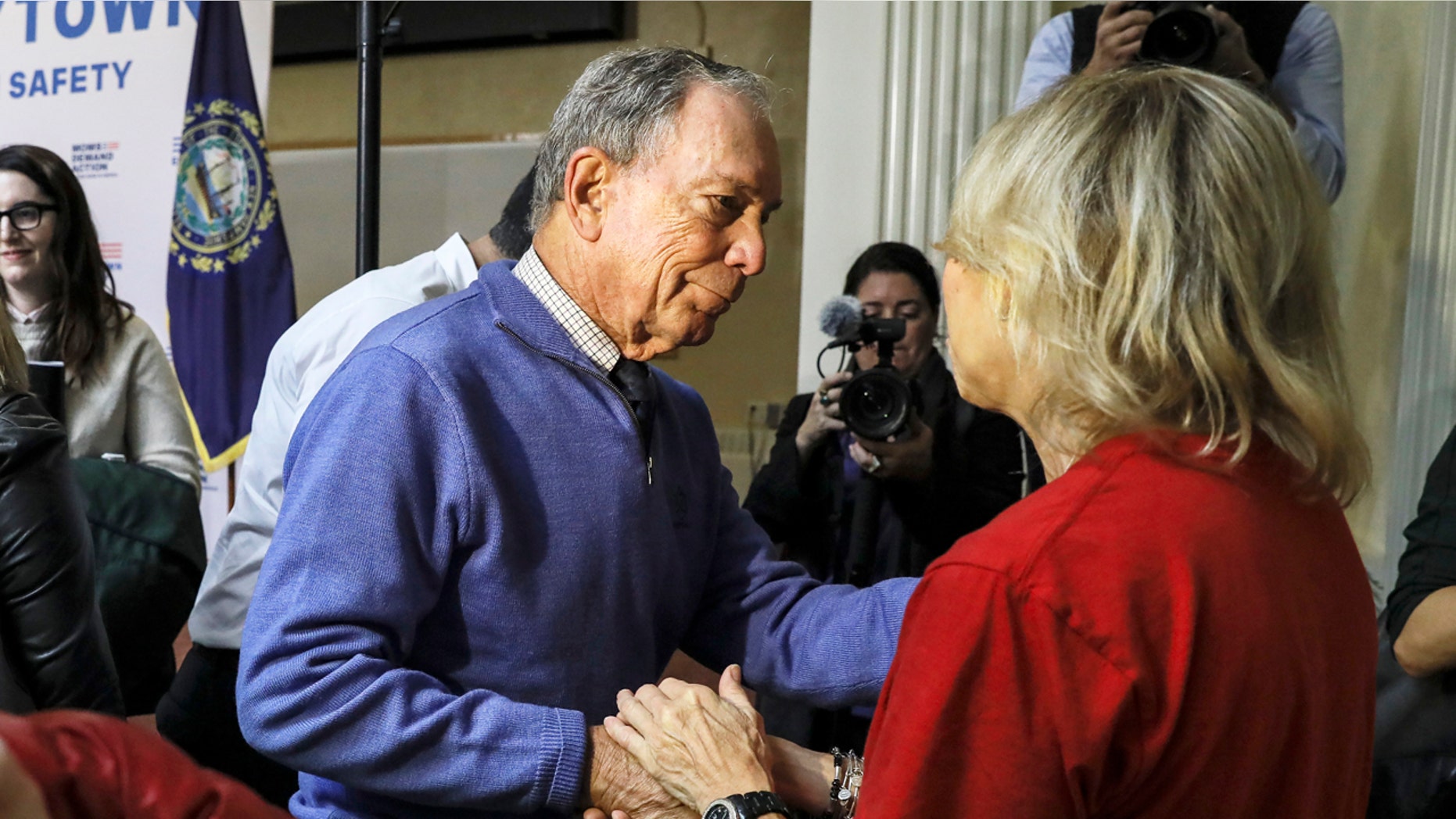 Former New York Mayor Michael Bloomberg talks to a woman who lost her daughter to gun violence after speaking at a rally at City Hall in Nashua, New Hampshire, on Saturday.