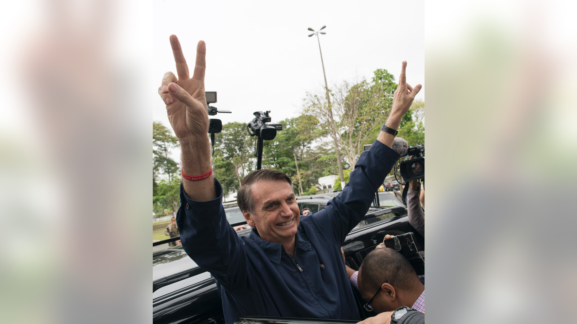 Presidential frontrunner Jair Bolsonaro, of the Social Liberal Party, flashes victory hand signs to supporters after voting at a polling station in Rio de Janeiro, Brazil, Sunday, Oct. 7, 2018. Brazilians choose among 13 candidates for president Sunday in one of the most unpredictable and divisive elections in decades. If no one gets a majority in the first round, the top two candidates will compete in a runoff. (AP Photo/Leo Correa)