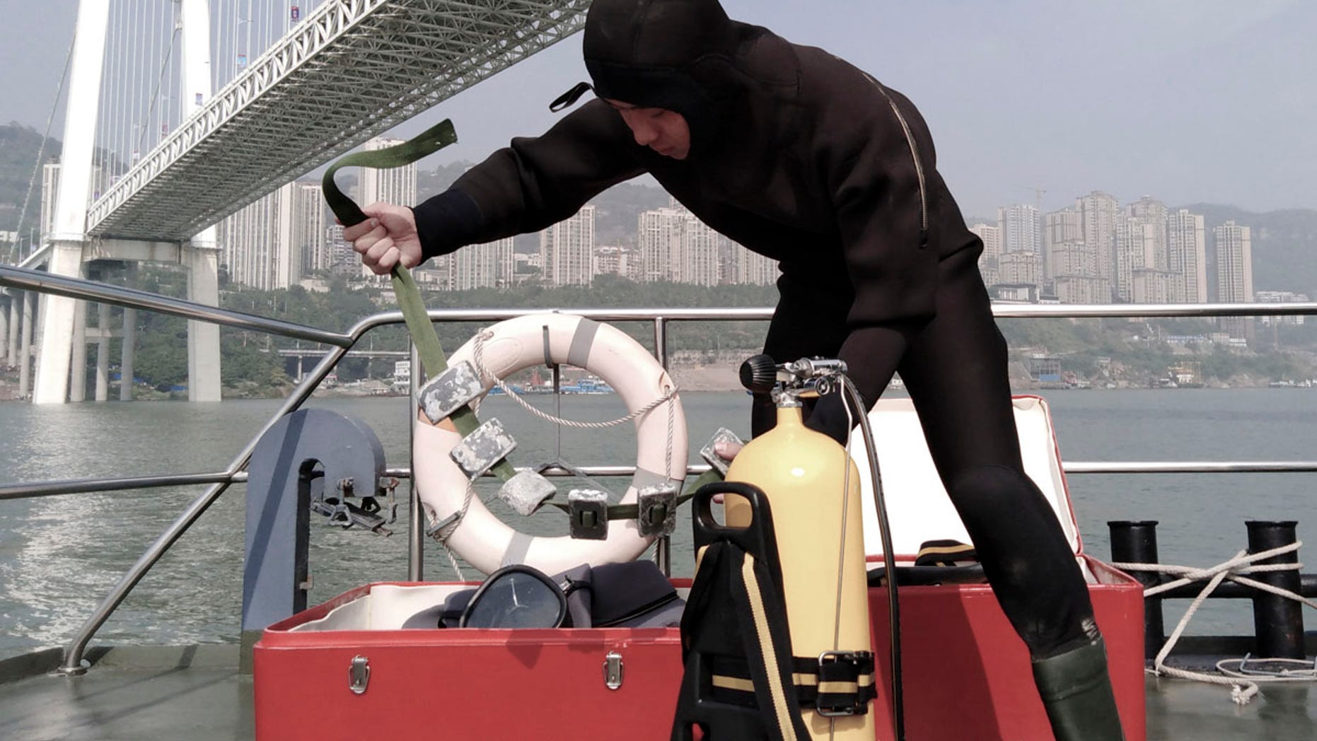 A diver prepares to conduct a search and rescue operation at the site where a bus has plunged off a bridge into the Yangtze River in Wanzhou in southwest China's Chongqing Municipality Sunday, Oct. 28, 2018