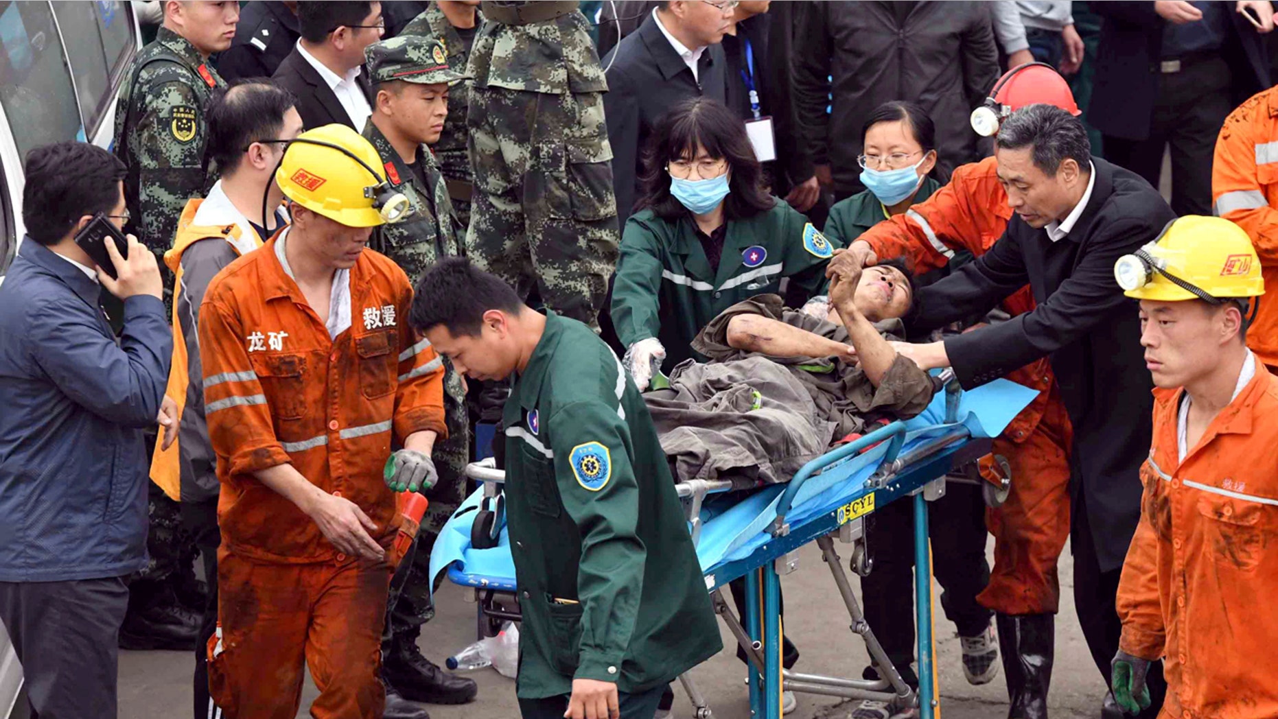 In this photo released by China's Xinhua News Agency, a worker is carried on a stretcher out of the Longyun coal mine in Yuncheng County, east China's Shandong Province, Sunday, Oct. 21, 2018.
