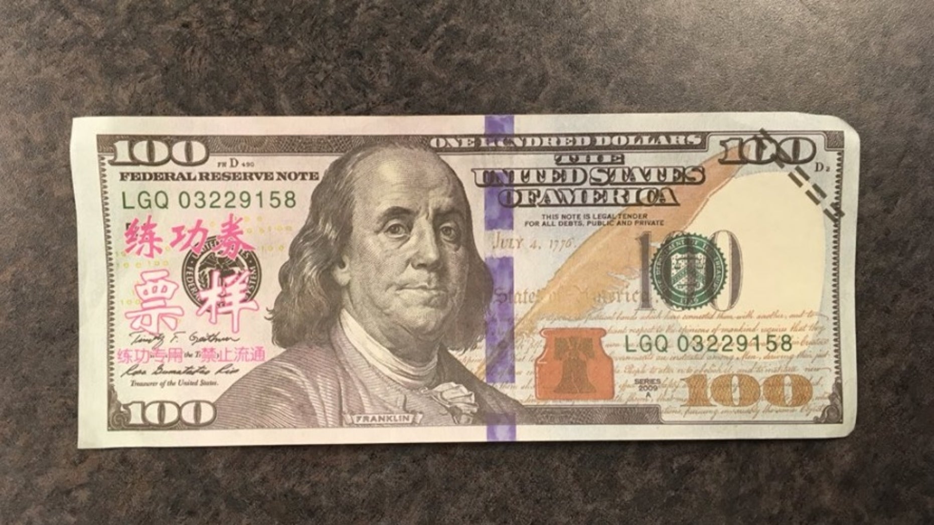 Woman tried to pass off fake 100 bills with pink Chinese