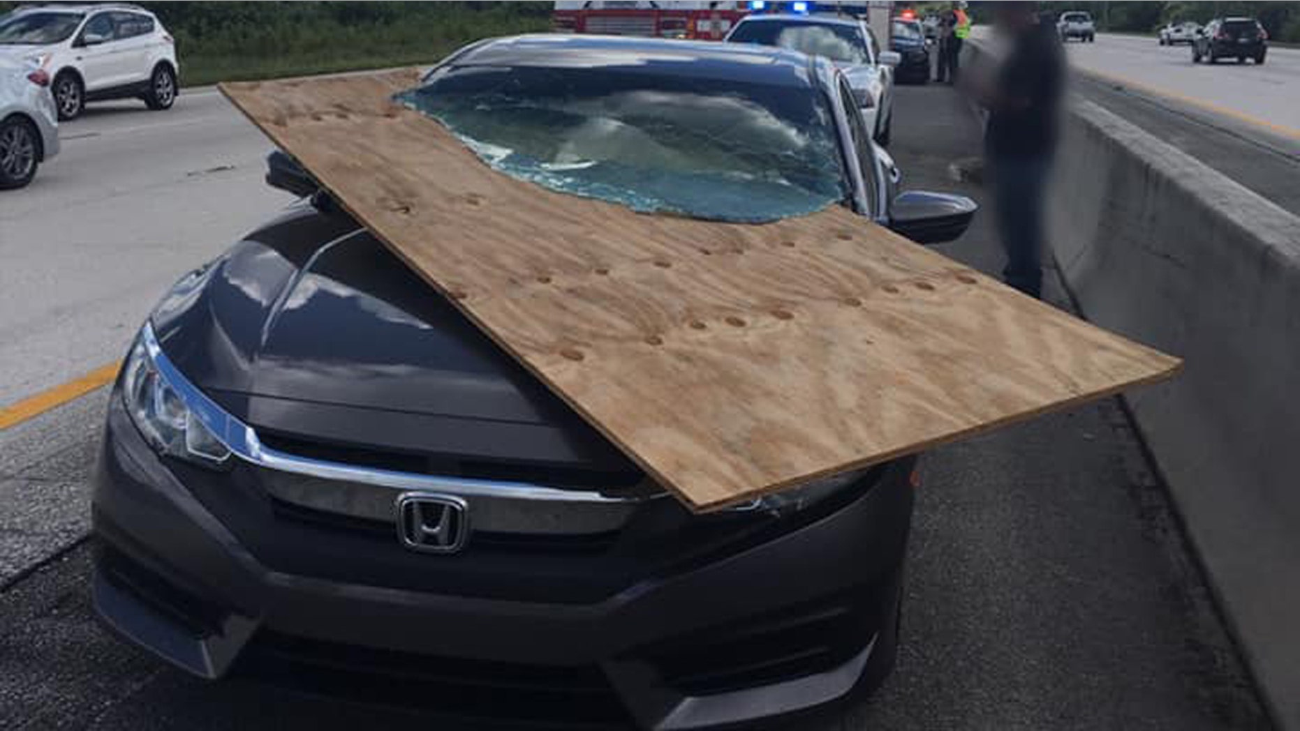 A motorist in Florida had a near-miss after a piece of plywood flew off a truck and became impaled in her windshield.