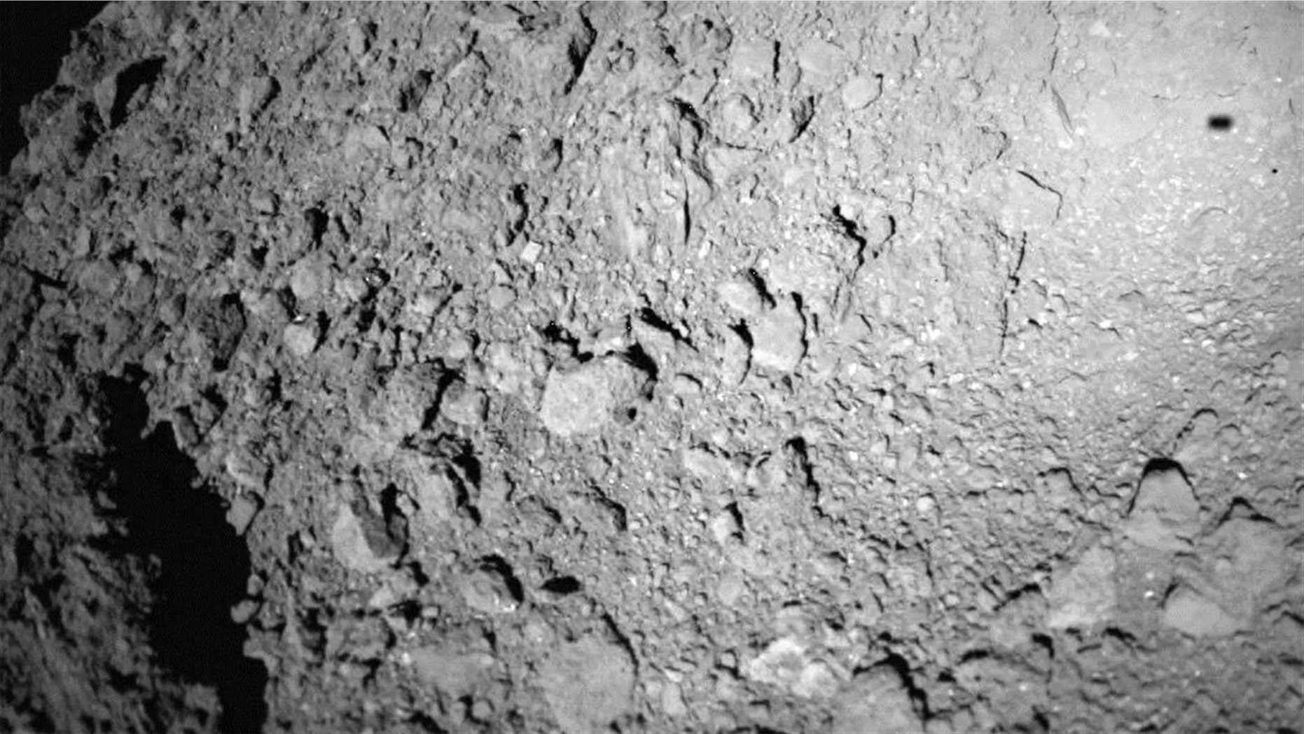 The German-French Mobile Asteroid Surface Scout (MASCOT) lander captured this photo of asteroid Ryugu during landing operations on Oct. 3, 2018. The lander's shadow is visible at upper right. Credit: German Aerospace Center (DLR)