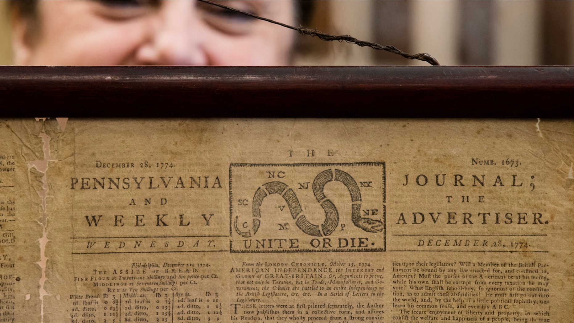 Heather Randall displays a Dec. 28, 1774, Pennsylvania Journal and the Weekly Advertiser at the Goodwill Industries in Bellmawr, N.J., Thursday.
