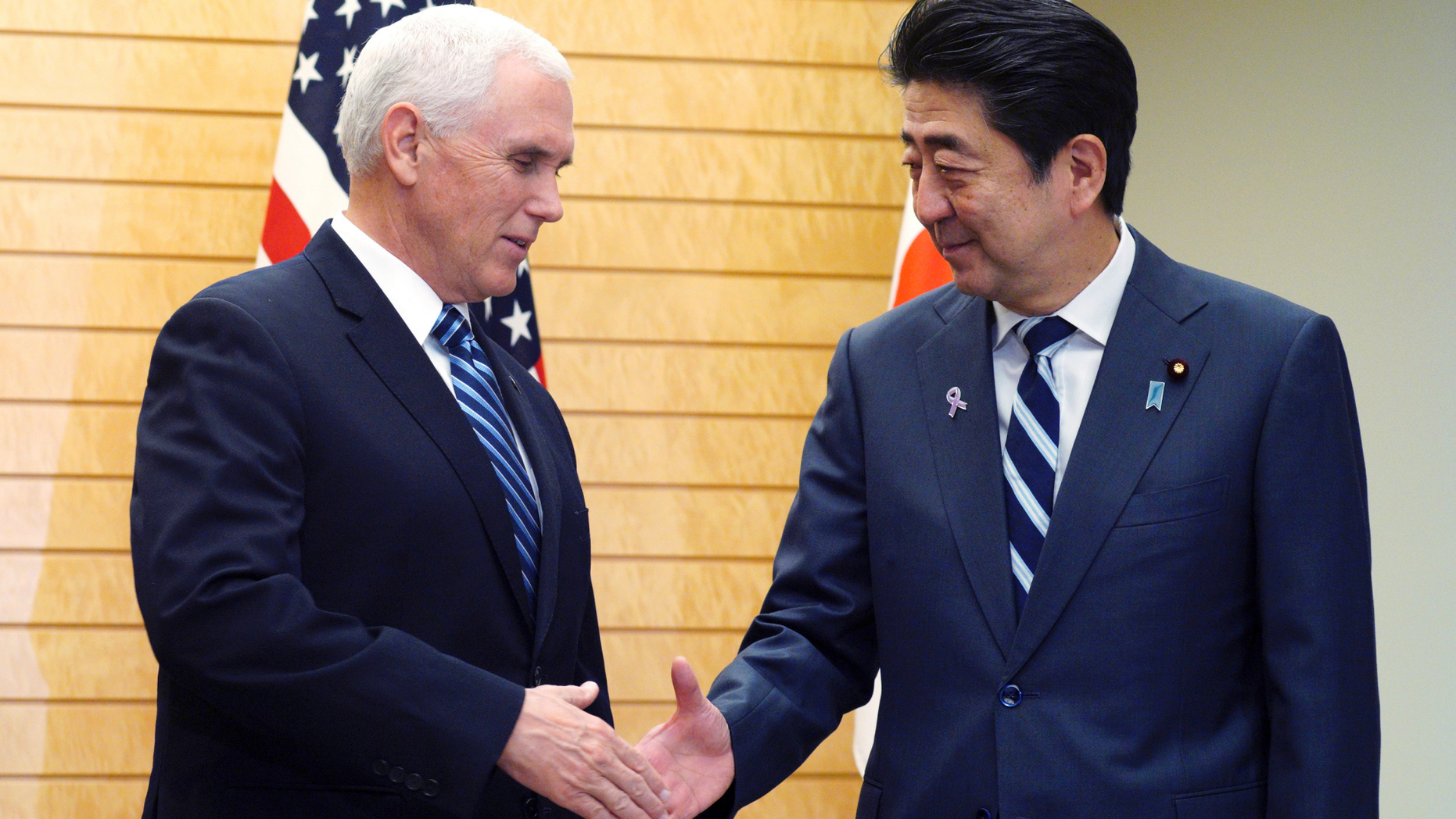 U.S. Vice President Mike Pence, left, and Japanese Prime Minister Shinzo Abe shake hands at Abe's official residence in Tokyo Tuesday, Nov. 13, 2018. (AP Photo/Eugene Hoshiko)