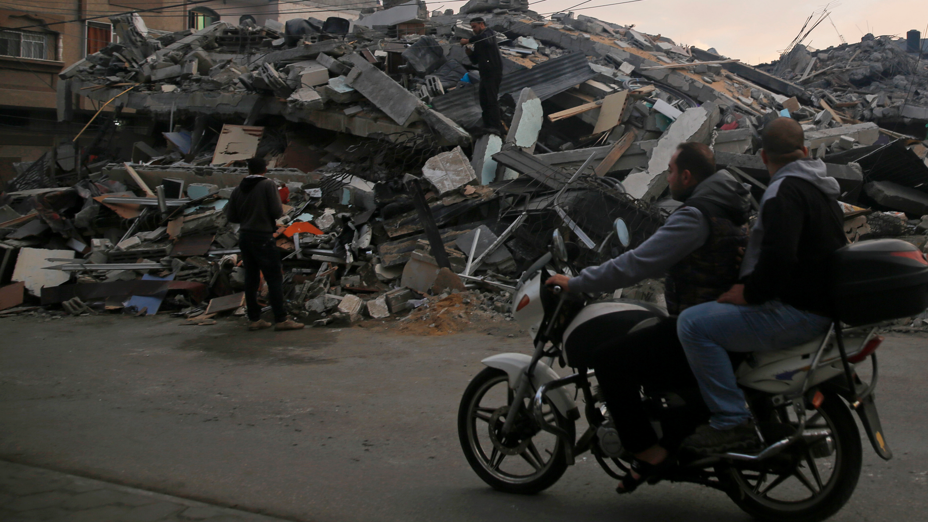 Palestinians survey a destroyed residential building hit by Israeli airstrikes, in Gaza City, Tuesday, Nov. 13, 2018. (AP Photo/Hatem Moussa)