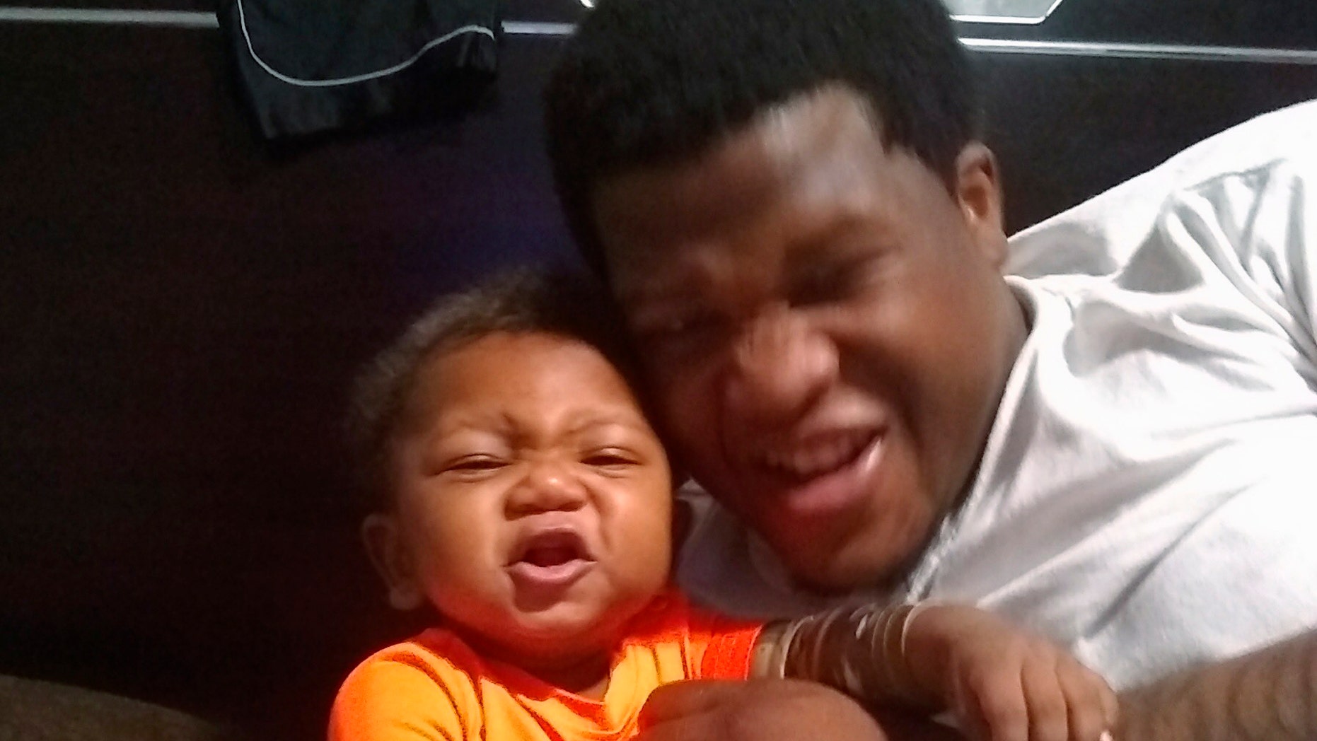This photo provided by Avontea Boose shows her baby Tristan Roberson and the boy's father Jemel Roberson. A police officer fatally shot Jemel Roberson, an armed security guard who was wearing a hat with "security" emblazoned across the front and holding a man down following a shooting inside the suburban Chicago bar where the guard worked, an attorney for the guard's family said Monday, Nov. 12, 2018, after filing a federal lawsuit. (Avontea Boose via AP)