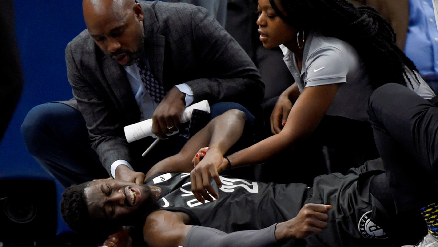 Brooklyn Nets guard Caris LeVert (22) is tended to after an injury during the second quarter of a game against the Minnesota Timberwolves.