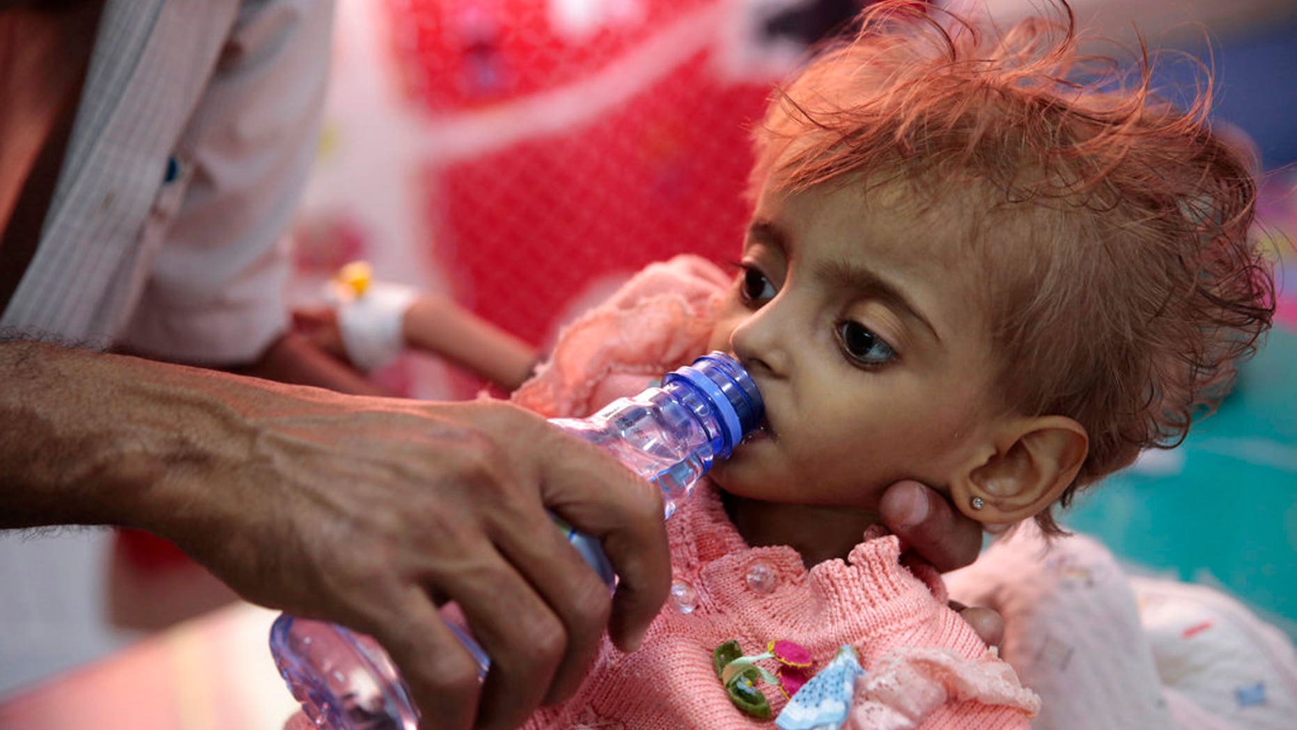 FILE: A father gives water to his malnourished daughter at a feeding center in a hospital in Hodeida, Yemen.
