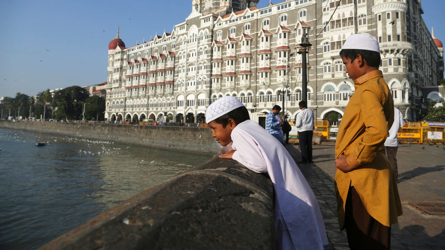 In this photo of November 17, 2018, two Muslim boys stand in front of the iconic Taj Mahal Palace, the epicenter of the 2008 terrorist attacks that killed 166 people in Mumbai, India.