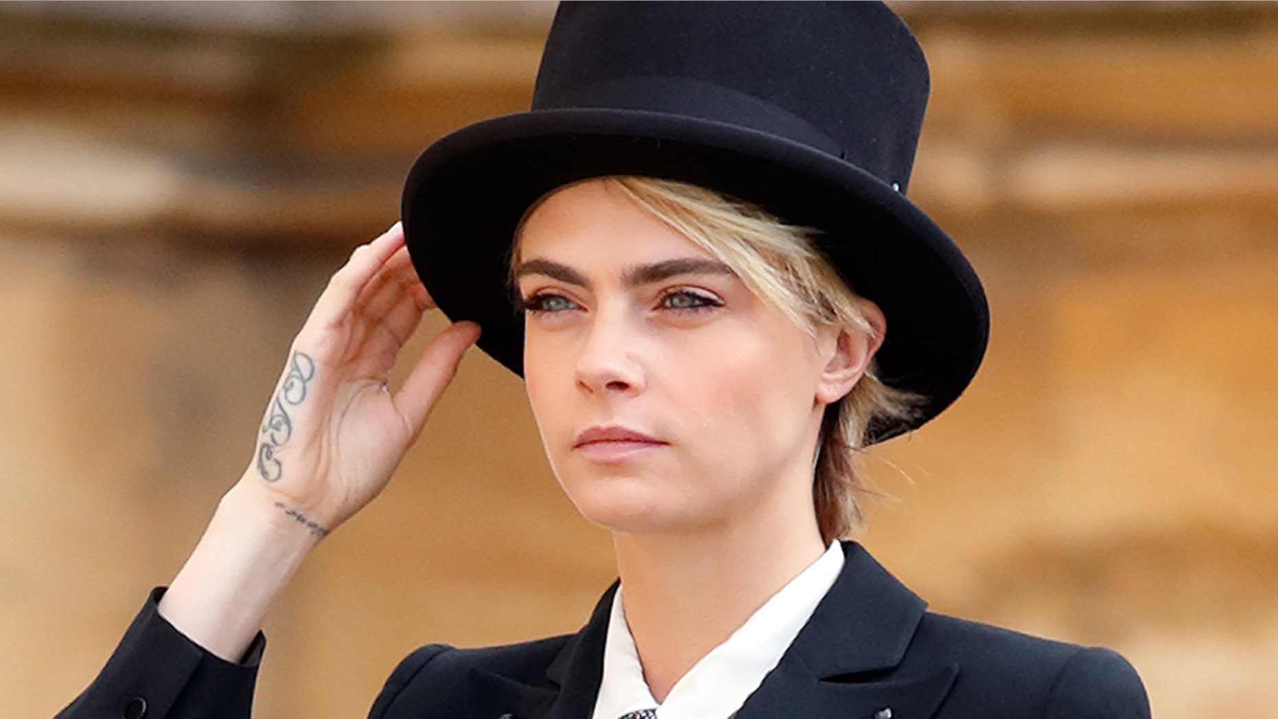 Cara Delevingne attended Princess Eugenie's royal wedding a suit and top hat.