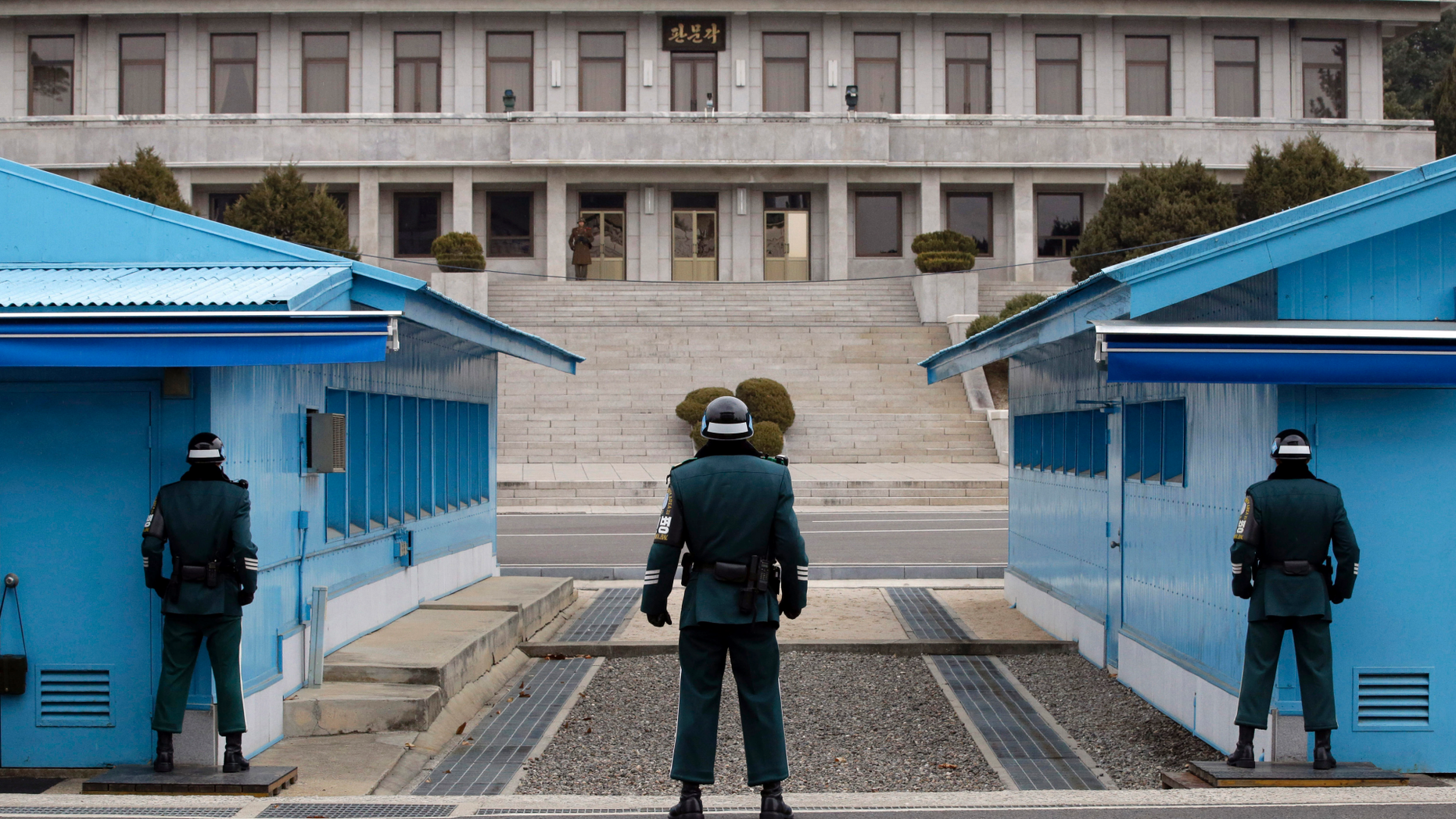 In this March 12, 2014, file photo, a North Korean soldier, center top, looks at the southern side as three South Korean soldiers guard at the border village of Panmunjom, which has separated the two Koreas since the Korean War, in Paju, South Korea.