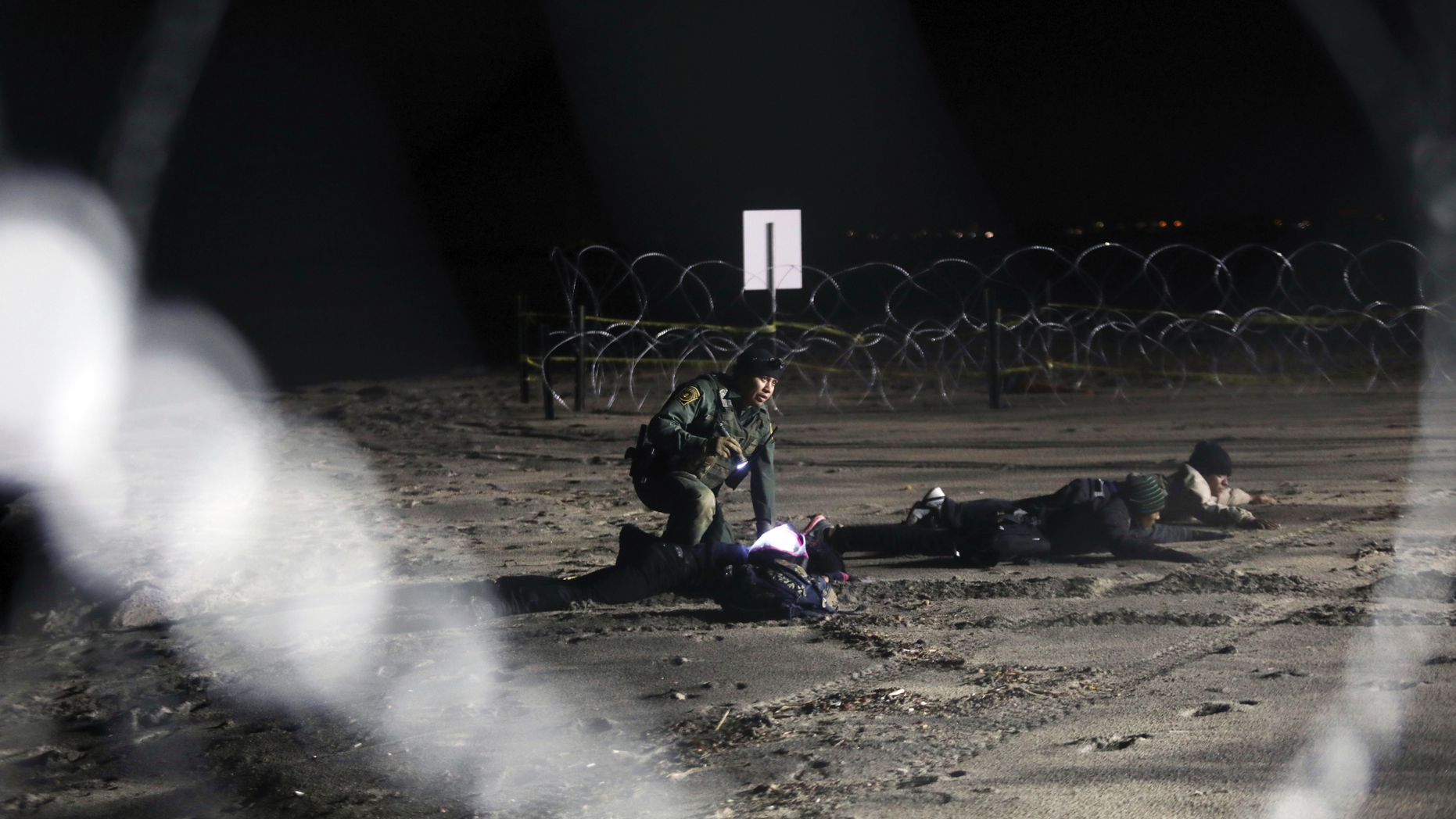 A U.S. Border Patrol detains Honduran migrants after they walked onto U.S territory from Tijuana, Mexico, Friday, Nov. 30, 2018. Thousands of migrants who traveled via a caravan members want to seek asylum in the U.S. but may have to wait months because the U.S. government only processes about 100 of those cases a day at the San Ysidro border crossing in San Diego. (AP Photo/Felix Marquez)