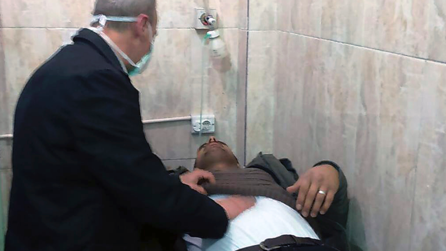 In this photo released by the Syrian official news agency SANA, shows a man receiving treatment at a hospital following a suspected chemical attack on his town of al-Khalidiya, in Aleppo, Syria, Saturday, Nov. 24, 2018. At least 41 civilians were being treated following a suspected poison gas attack by Syrian rebel groups on government-held Aleppo city in the country's north, according to Syrian state media. (SANA via AP)