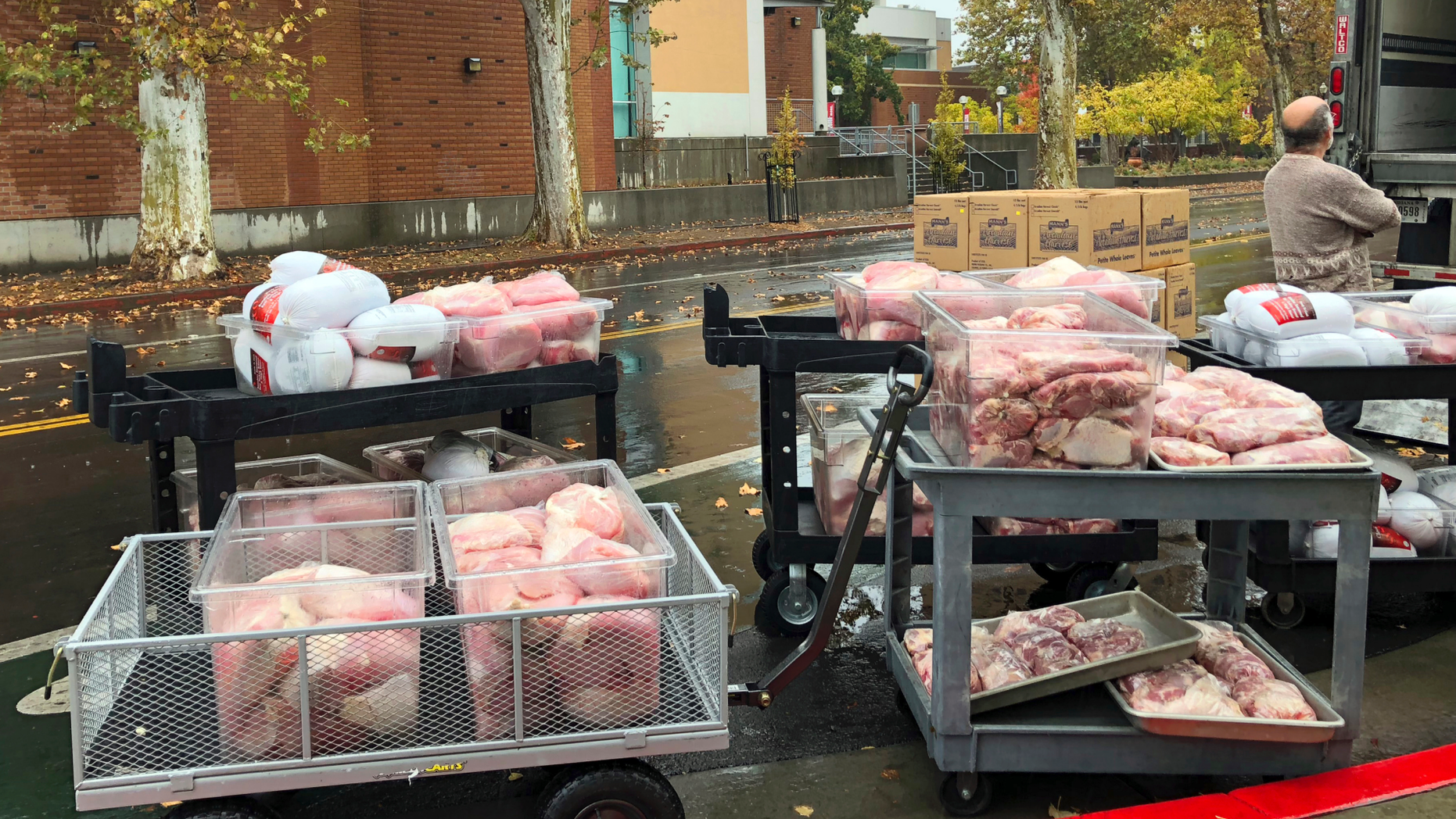 Hundreds of frozen turkeys are unloaded on the campus of California State University, in Chico, Calif., Wednesday, Nov. 21, 2018. The nonprofit World Central Kitchen is preparing them for a Thanksgiving meal for residents displaced by the Camp Fire in Northern California. The fire ignited Nov. 8 and devastated Paradise, Calif., and surrounding communities. (AP Photo/Kathleen Ronayne)